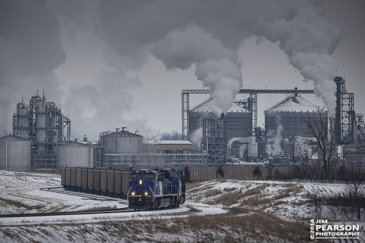 January 20, 2016 - Evansville Western Railway's SS1 pulls away from the Sitran Dock with a empty coal train with lease units SVTX 1986 and 1982 as power, at West Franklin, Indiana on a cold wintery day. In the background putting out all the steam is the Abengoa Bioenergy plant.  - Tech Info: 1/1250 | f/6.3 | ISO 400 | Lens: Sigma 150-600 @ 310mm with a Nikon D800 shot and processed in RAW.