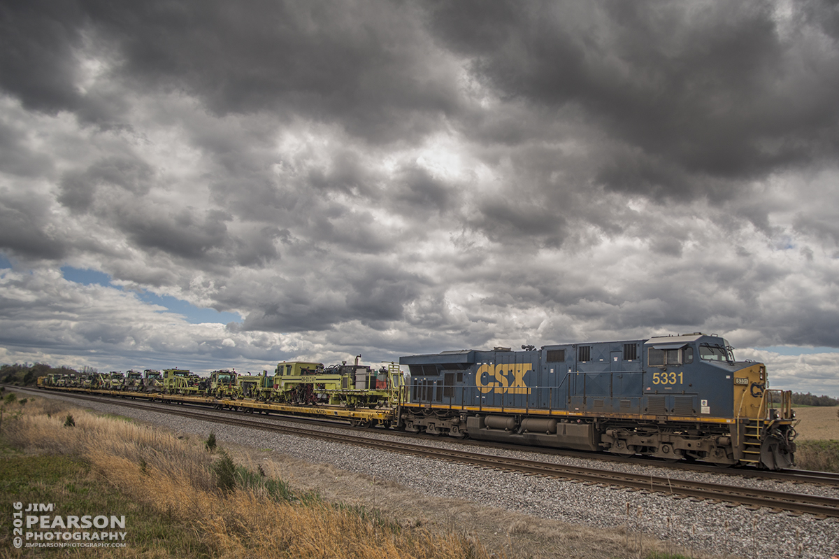 April 8, 2016 - CSX MOW Train C019-08 heads north, under stormy skies, at Slaughters, Ky on the Henderson Subdivision with a load of MOW equipment. For several weeks part of the Henderson Sub has been undergoing upgrades and now with that work completed all the equipment is starting to head off to other locations. - Tech Info: 1/2000 | f/2.8 | ISO 125 | Lens: Nikon 18mm on a Nikon D800 shot and processed in RAW.