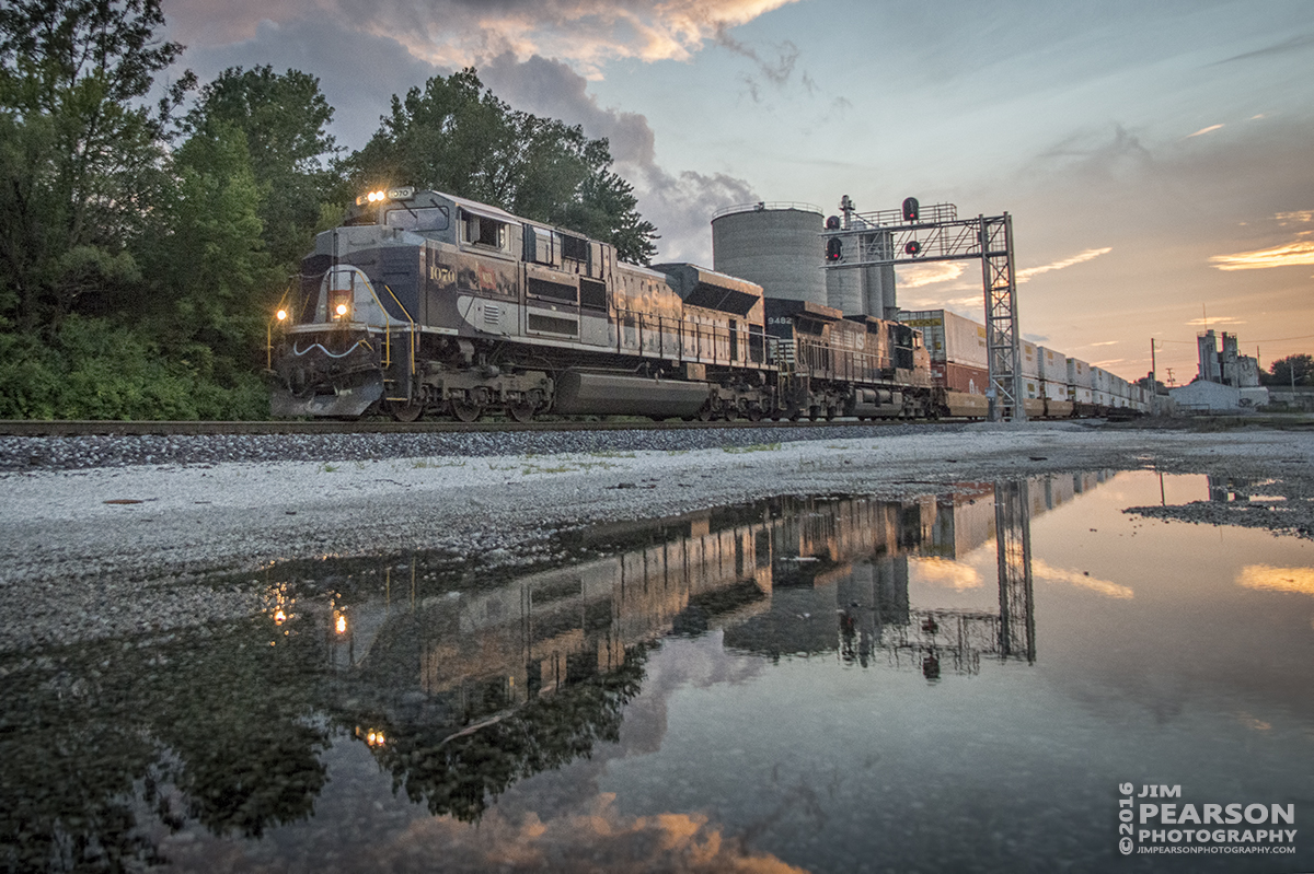 August 20, 2016 - Norfolk Southern Wabash Heritage Unit, 1070, is reflected in standing water, as it makes its way east into the yard at Princeton, Indiana on NS 223 with a loaded intermodal at sunset.