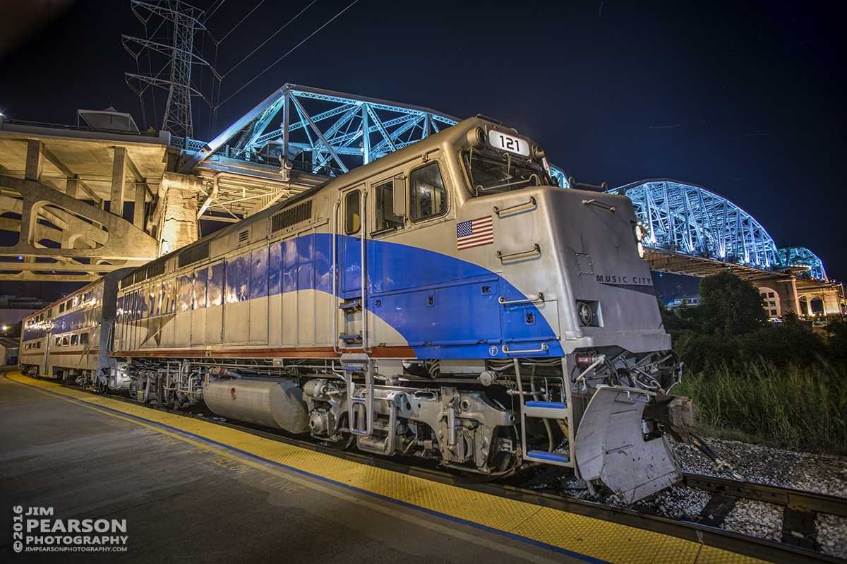 September 9, 2016 - A Music City Star commuter train with engine 121 (F40PH), sits along the river front in downtown Nashville, Tennessee, with the John Seigenthaler Pedestrian Bridge lit-up in the background.