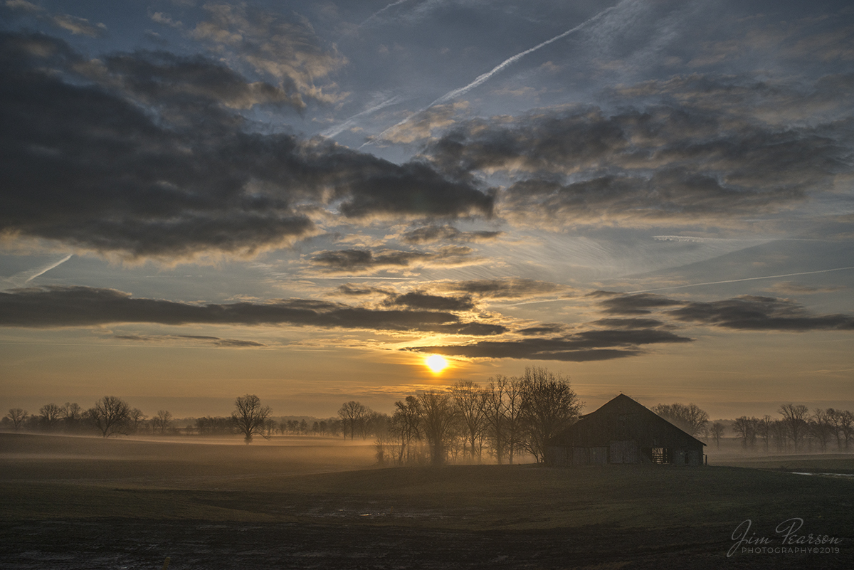 April 6, 2019 - The early morning sun rises over a country barn on hwy 60, between Henderson and Morganfield, Key as a light fog drifts in the valley.