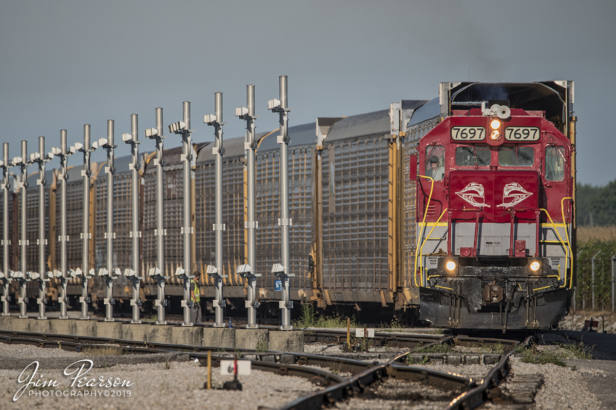 August 24, 2019 - RJ Corman 7697 spots a string of empty autoracks in the Toyota Yard at Princeton, Indiana. The poles to the left are for lights for operating after dark.