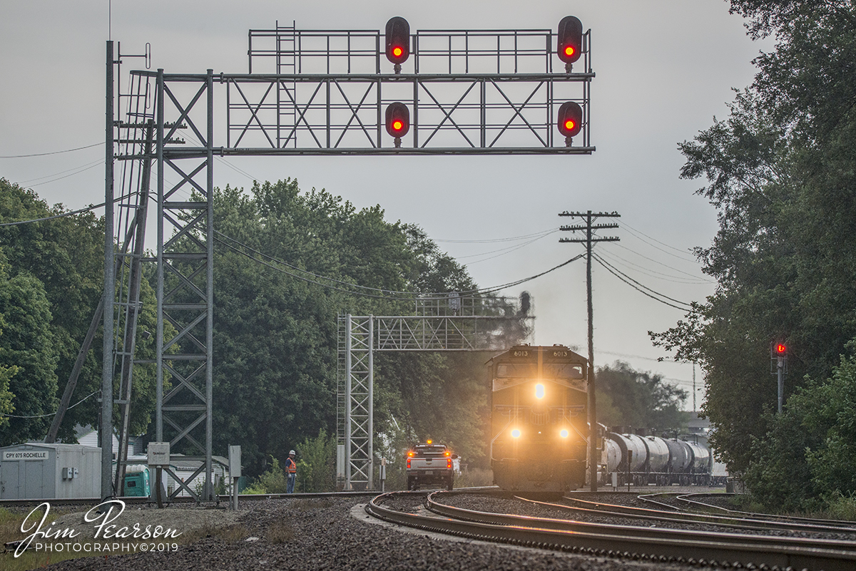September 9, 2019 - Union Pacific 6013 leads a mixed freight over the BNSF Aurora Subdivision, at the diamond, as a track inspector watches from the side as it heads westbound on the the UP Geneva Subdivision at Rochelle, Illinois.