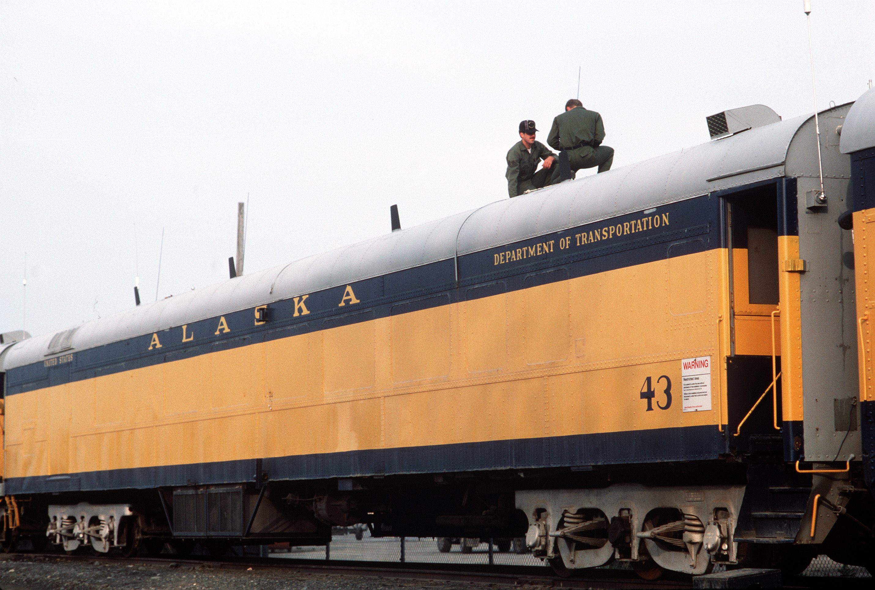 SSGT Bill Lovins, ground radio maintenance, left, and SSGT Randall Brinlee, teletype communications operator, install communications antennas on one of several converted railway cars which function as the Alaskan Air Command's Alternate Command Post.  Both men are assigned to the 1930th Information Systems Squadron.