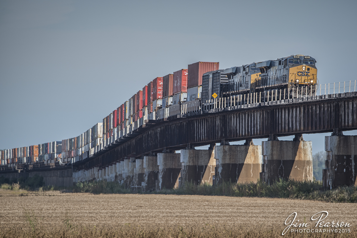 October 5, 2019 - CSX Q025-04 heads up the viaduct to the bridge over the Ohio River between Rahm, Indiana and Henderson, Kentucky as it heads south on the Henderson Subdivision on this beautiful fall morning with a wall of containers and a Geometry Test Car behind the lead units.