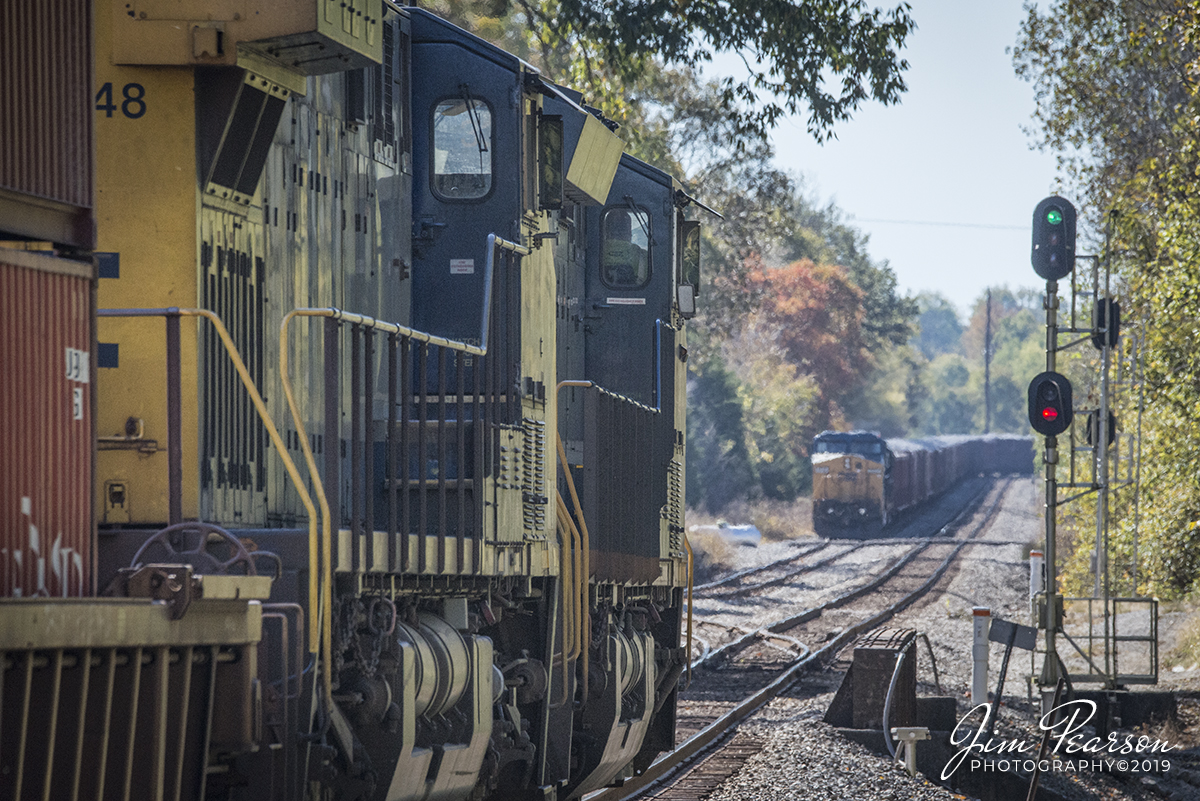October 23, 2019 - Southbound CSX Intermodal Q025-23 prepares to pass the signals at the north end of Latham Siding at Hopkinsville, Kentucky on the Henderson Subdivision as loaded ballast train, W089 waits to continue it's move north, from the siding.
