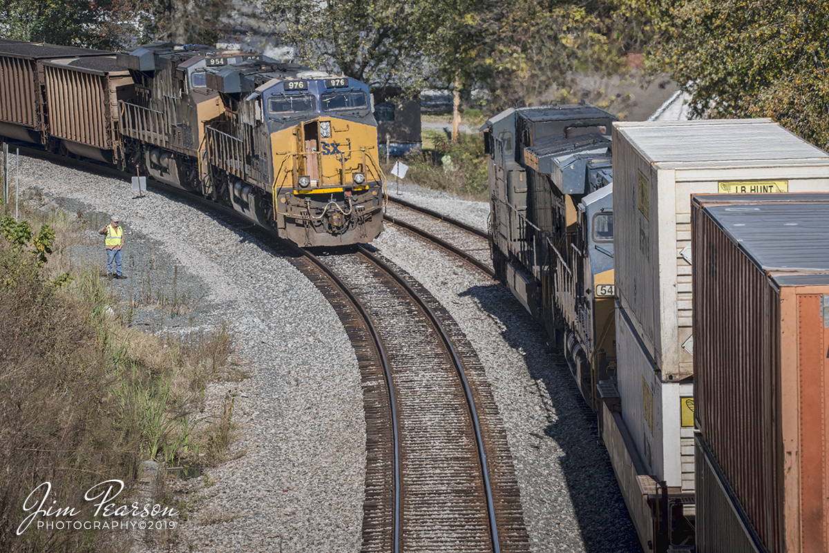 October 23, 2019 - A crewmember from loaded coal train CSX N013 waves at the engineer on northbound Intermodal CSX Q028 as they meet at Nortonville, Kentucky on the Henderson Subdivision as he performs a roll by inspection.