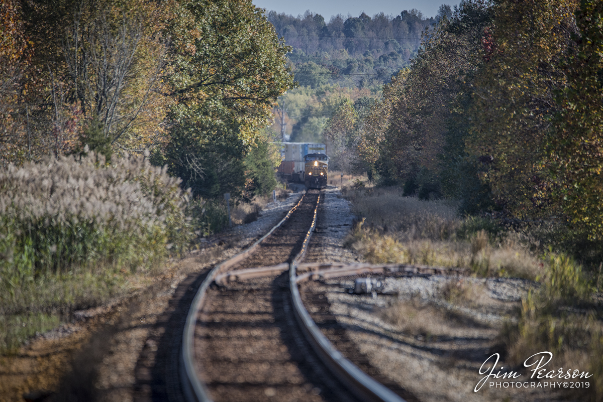 October 24, 2019 - CSX Intermodal Q028-23 heads north on the Henderson Subdivision as it approaches the Hubert Reid Road Crossing at Earlington, Ky on a beautiful fall afternoon. The switch that goes off to the right is the seldom used house track at Earlington. 

According to Wikipedia: Founded in 1870 by the St. Bernard Coal Co., Earlington was named a year later upon its incorporation for John Baylis Earle, the man who stuck the first pick into the hillside at the opening of Hopkins County's first commercial coal mine. Earle was a lawyer who was central to developing the coal industry in the region.

Shortly after the town was founded, the Louisville and Nashville Railroad completed its line from Henderson to Earlington, and became the primary hauler in the area. The town boomed as both a coal center and as the center of L&N operations on the Evansville line.