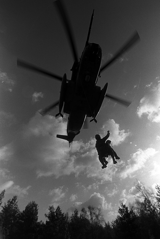 Blast From The Past - December 10, 1982 - SSGT James Norton, a pararescueman from the 67th Aerospace Rescue and Recovery Squadron, and a "downed" pilot are hoisted aboard an HH-53 Super Jolly helicopter during pararescue training at Mildenhall AB, United Kingdom. - USAF Photo by SSgt. James R. Pearson