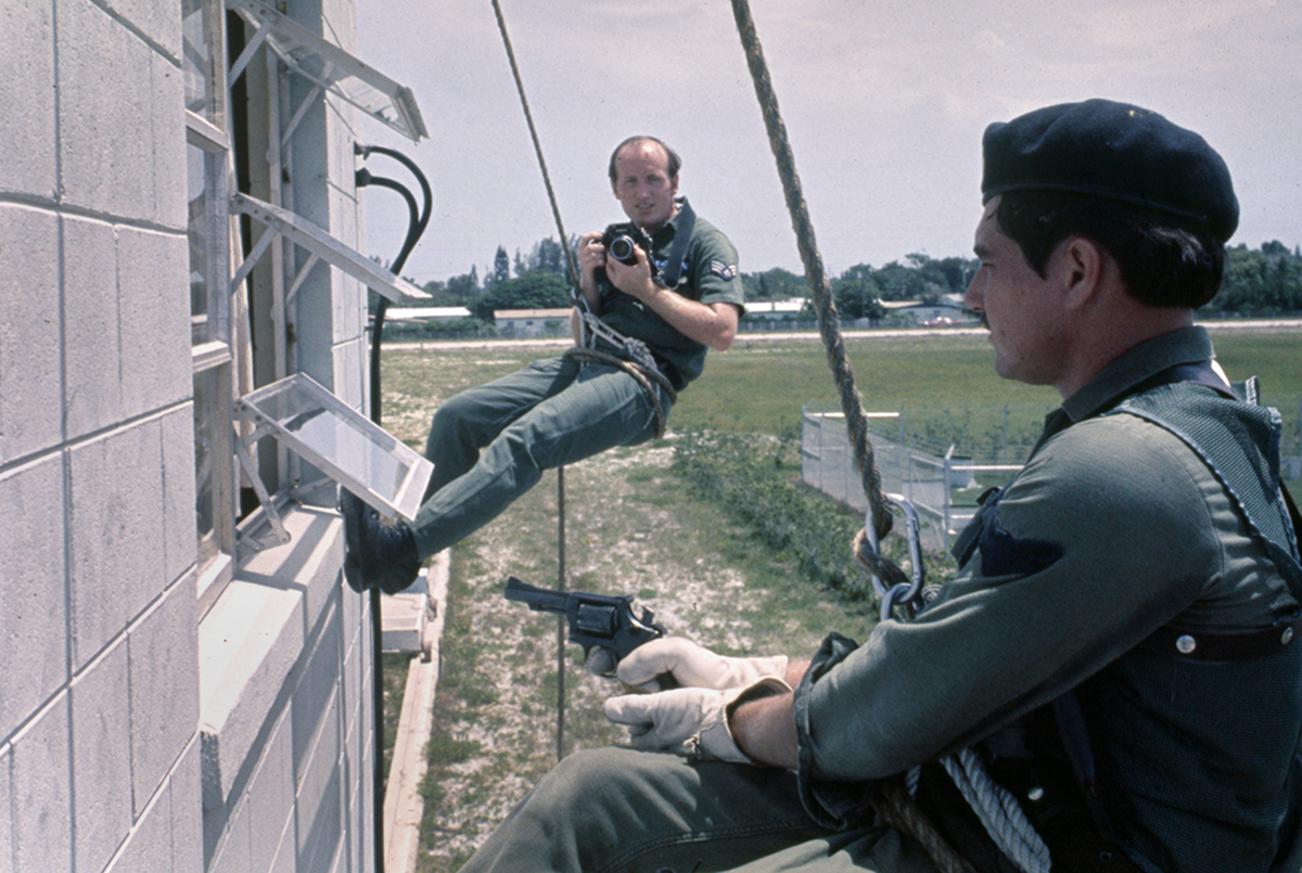 Blast From The Past - 1976 - Here I'm hanging off a building after repelling down to take a picture at Patrick Air Force Base, Florida. I was on assignment to cover the training of the very first Air Force SWAT team and as always, looking for that unique perspective that helps tell the story. Over the years I've hung from the bottom of a helicopter tethered to a rope at 500+ feet in the air shooting pictures, to the backseat of a Norwegian fighter jet covering the first Artic Testing of the F-16 fighter and a lot other interesting locations and assignments over the years.