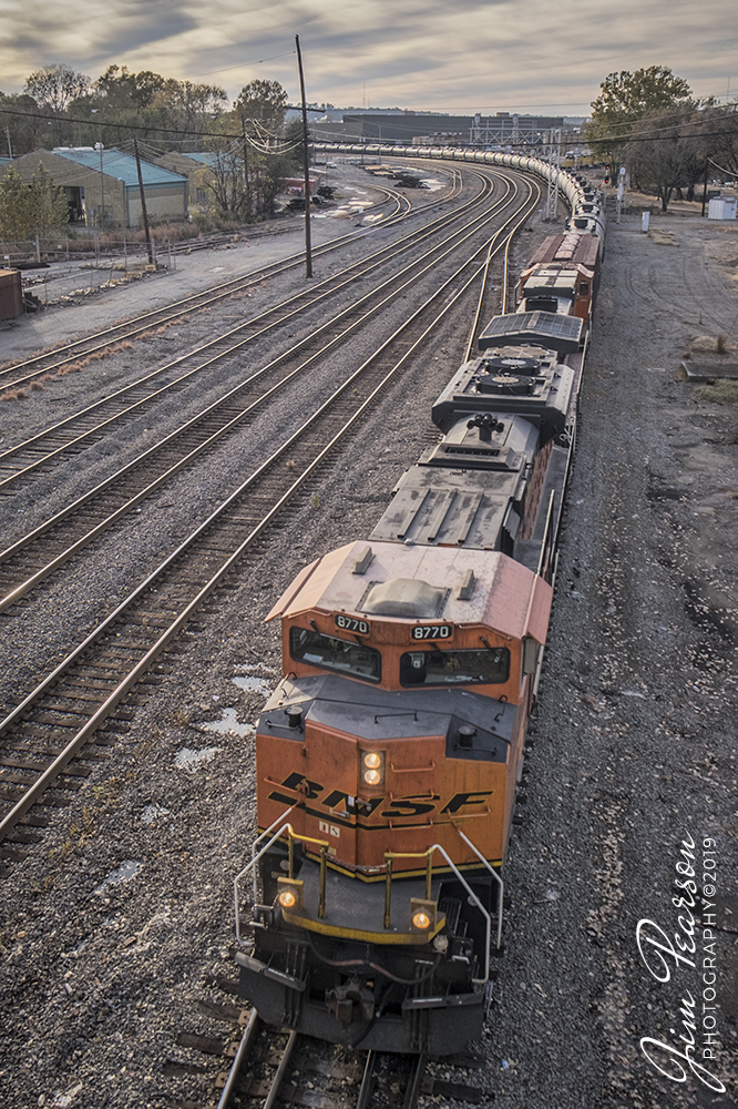 November 13, 2019 - A BNSF tank Train heads through Union Pacific's Locust Street Yard at Little Rock, Arkansas, with BNSF 8770 leading the way, as it approaches the Main Street Overpass.