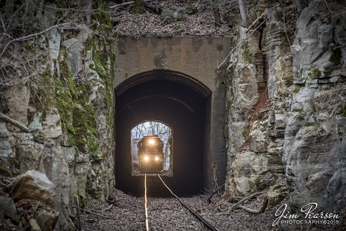 December 20, 2019 - RJ Corman's Cumberland City turn local prepares to enter Palmyra Railroad Tunnel as it makes it's return trip northbound on the Memphis Line at Palmyra, Tennessee with RJC 3801 and 3837 leading with their long noses forward elephant style for their return trip to Guthrie, Ky.

Palmyra is a very small town southwest of Clarksville, TN and from what I can find the tunnel is about 800-1000 ft. long.

The Memphis line follows the Cumberland River between Clarksville and Cumberland City and here at Palmyra, there is a large bluff overlooking the river which required a tunnel to be blasted through it. 

The line was originally built by the Memphis, Clarksville & Louisville Railroad (MC& L) which eventually became part of L&N.
