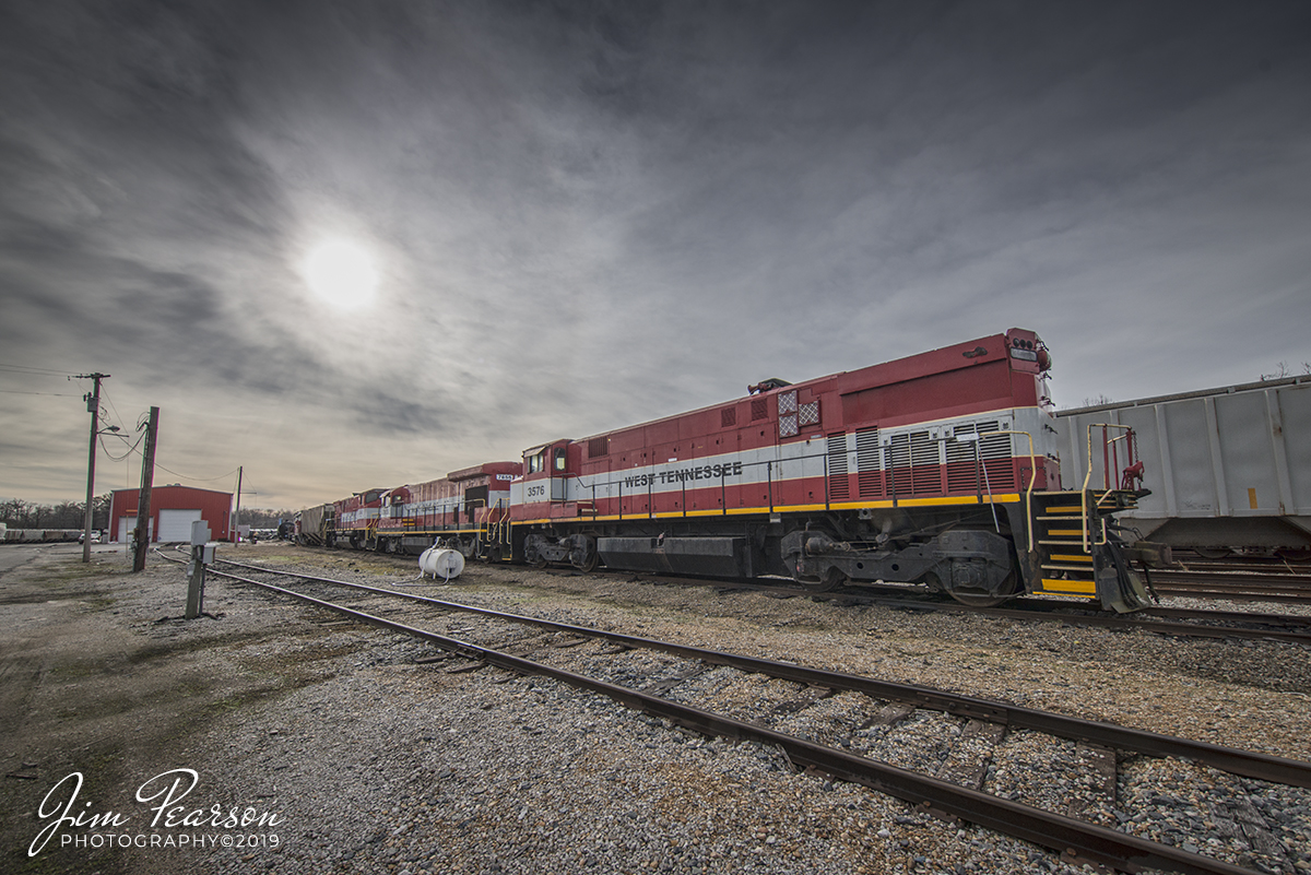 January 1, 2020 - A string on power sits next to the engine house at the West Tennessee Railroad engine house at their yard in Jackson, Tennessee on a very quiet New Years Day. From front to back are, 3576, 7855, 3560 and SCTR 483 (The Duck River Route).

According to Wikipedia: The West Tennessee Railroad (reporting mark WTNN) is a shortline railroad in the Southern U.S., connecting Corinth, Mississippi, to Fulton, Kentucky, via western Tennessee. The company began operating in 1984 on a portion of the former Mobile and Ohio Railroad (M&O) main line between Jackson and Kenton, Tennessee. 

It significantly expanded operations in 2001 through the lease, from the Norfolk Southern Railway, of the ex-M&O south to Corinth and a former main line of the Illinois Central Railroad (IC) north to Fulton, as well as a branch from Jackson to Poplar Corner (ex-Birmingham and Northwestern Railway, acquired by the Gulf, Mobile and Northern Railroad in 1924). 

All of these lines were part of the Illinois Central Gulf Railroad (ICG) prior to its 1980s program of spin-offs, during which Gibson County purchased the Jackson-Kenton line and the Southern Railway acquired the Corinth-Fulton line and Poplar Corner branch.

The company is under common control with the South Central Tennessee Railroad and the Tennken Railroad. Its main line was upgraded as part of the MidAmerica Corridor, an initiative by the Canadian National Railway and Norfolk Southern Railway to improve rail service between Illinois and the Southeast.

The Mobile and Ohio Railroad completed a line between Mobile, Alabama, and Columbus, Kentucky, in 1861, and the Mississippi Central Railroad, an Illinois Central Railroad predecessor, completed its north-south line between New Orleans, Louisiana and Cairo, Illinois in 1873. The Birmingham and Northwestern Railway opened a line between Jackson, where the M&O and IC lines crossed, and Dyersburg in 1912 and was purchased by the Gulf, Mobile and Northern Railroad in 1924. Through mergers, all of these lines became part of the Illinois Central Gulf Railroad in 1972.

The Gibson County Railroad Authority acquired the line between Jackson and Kenton in August 1984, and the new West Tennessee Railroad began operations in October that same year.[5] The Southern Railway bought the Corinth-Jackson-Fulton and Jackson-Poplar Corner lines from the ICG in June 1988,[6] and in August 2001 the Norfolk Southern Railway, successor to the Southern, leased them to WTNN. (The Southern also acquired the ICG's line southeast to Haleyville, Alabama, and trackage rights from Fulton north to Centralia, Illinois, and NS sold the former, where not abandoned, to the Redmont Railway in 1995.)
