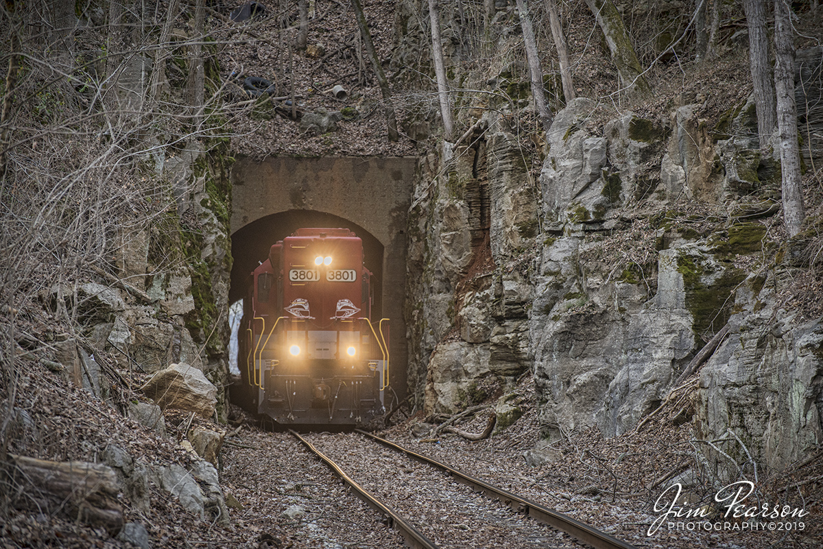 December 20, 2019 - RJ Corman's Cumberland City turn local exits Palmyra Railroad Tunnel as it makes it's return trip northbound on the Memphis Line at Palmyra, Tennessee with RJC 3801 and 3837 leading with their long noses forward elephant style for their return trip to Guthrie, Ky.

Palmyra is a very small town southwest of Clarksville, TN and from what I can find the tunnel is about 800-1000 ft. long.

The Memphis line follows the Cumberland River between Clarksville and Cumberland City and here at Palmyra, there is a large bluff overlooking the river which required a tunnel to be blasted through it. 

The line was originally built by the Memphis, Clarksville & Louisville Railroad (MC& L) which eventually became part of L&N.