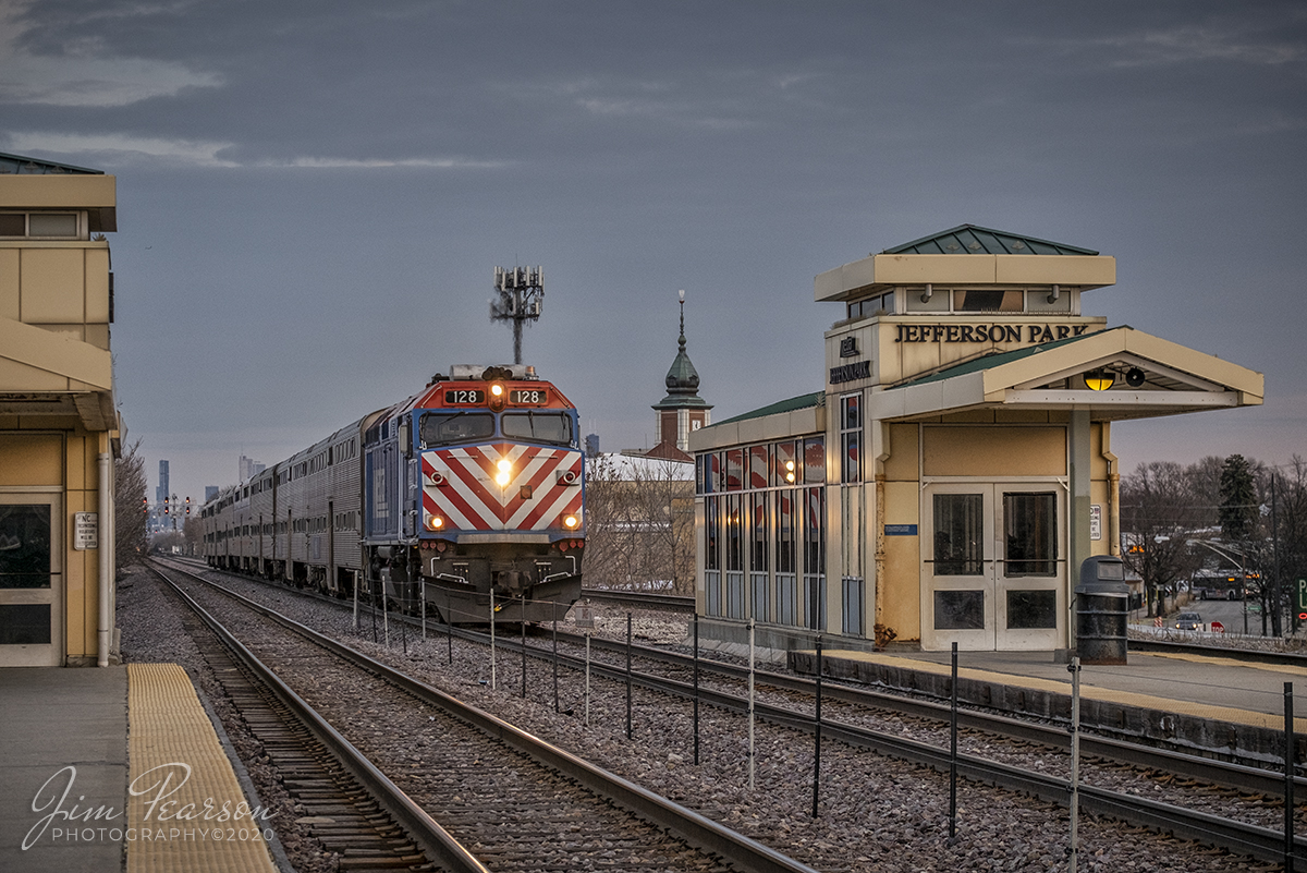 February 19, 2020 - An southbound Metra train arrives at the Jefferson Park Metra Station with engine128 leading during the evening rush hour from downtown Chicago, Illinois as the golden light of the day begins to fade from the sky.