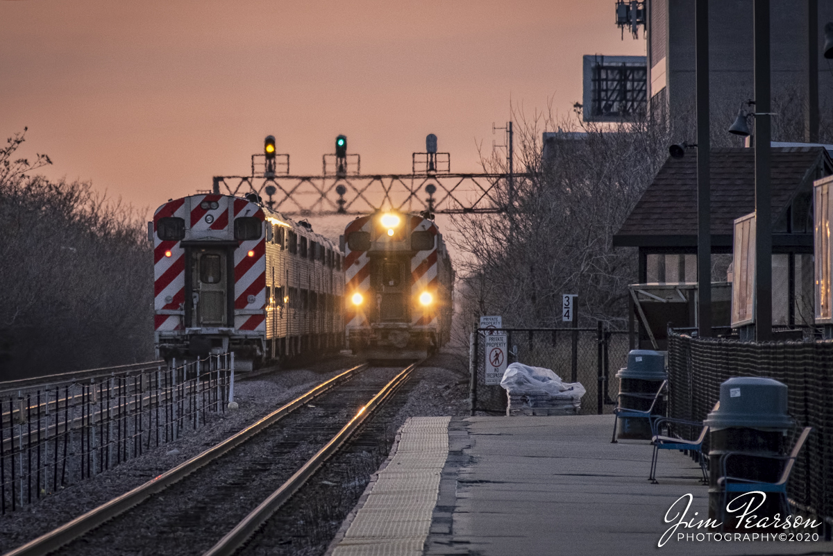 February 19, 2020 - An outbound and inbound Metra train pass each other at the Jefferson Park Metra Station during the evening rush hour to and from downtown Chicago, Illinois as the golden light of the day begins to fade from the sky.