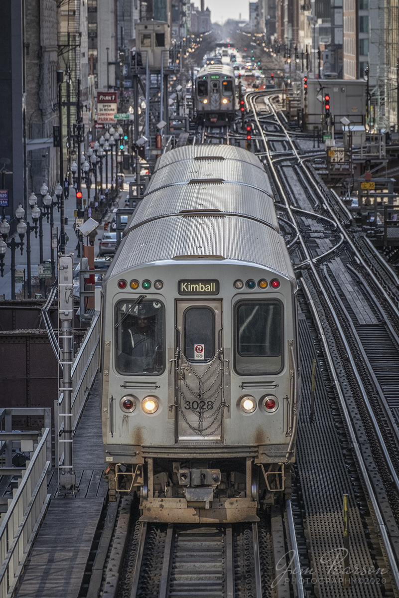 February 20, 2020 - Chicago Transit Authority brown line train 414 to Kimball makes its way on the downtown Chicago "L" loop as a green line train waits for a clear at CTA Tower 12 at the Van Buren & Wabash junction, as they head toward the Adams/Walbash Station in downtown Chicago, Illinois.