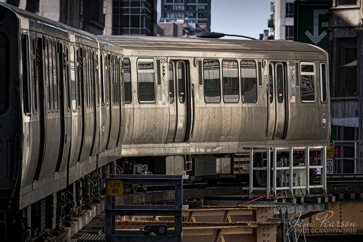 February 20, 2020 - A Chicago Transit Authority Orange Line Train to Midway makes a turn on the downtown Loop as light from a nearby building illuminates the side of it's train in downtown Chicago, Illinois.