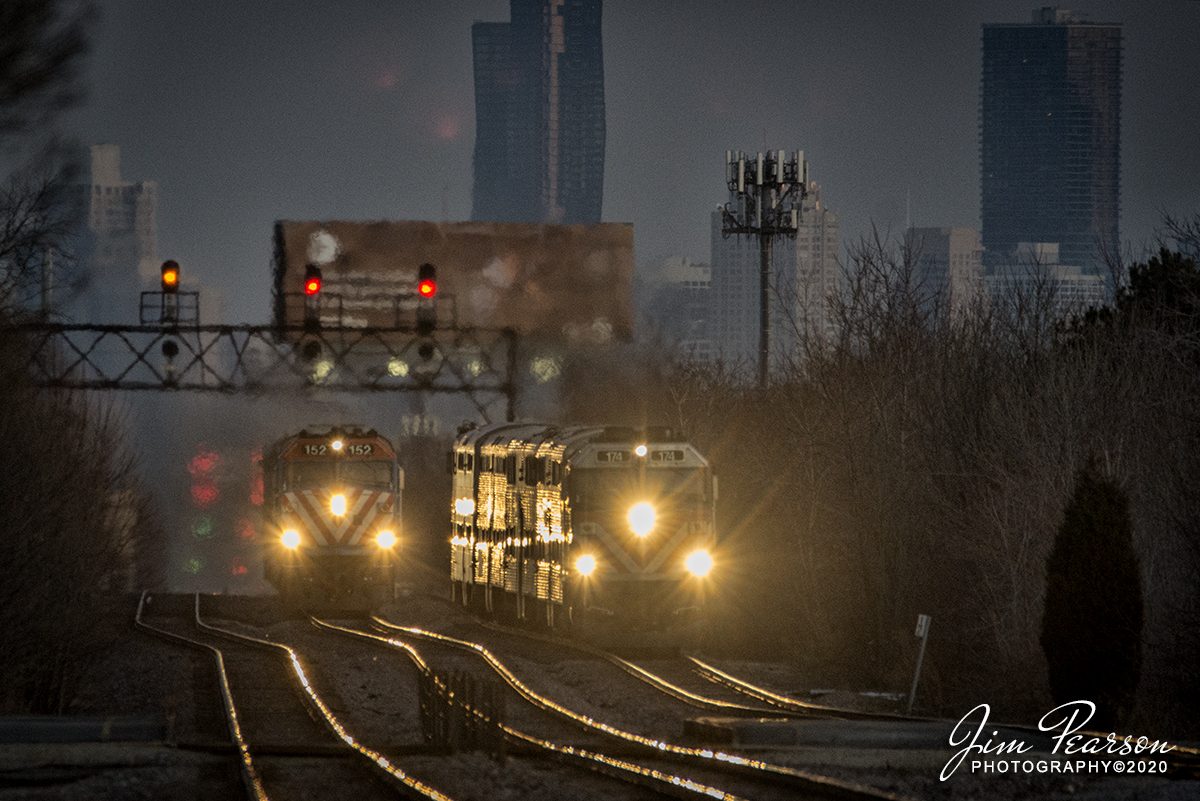 February 20, 2020 - A Metra Express train passes another Metra local as they approach the Gladstone Park station on the UP-NW Line as they head northwest out of Chicago, Illinois at dusk.