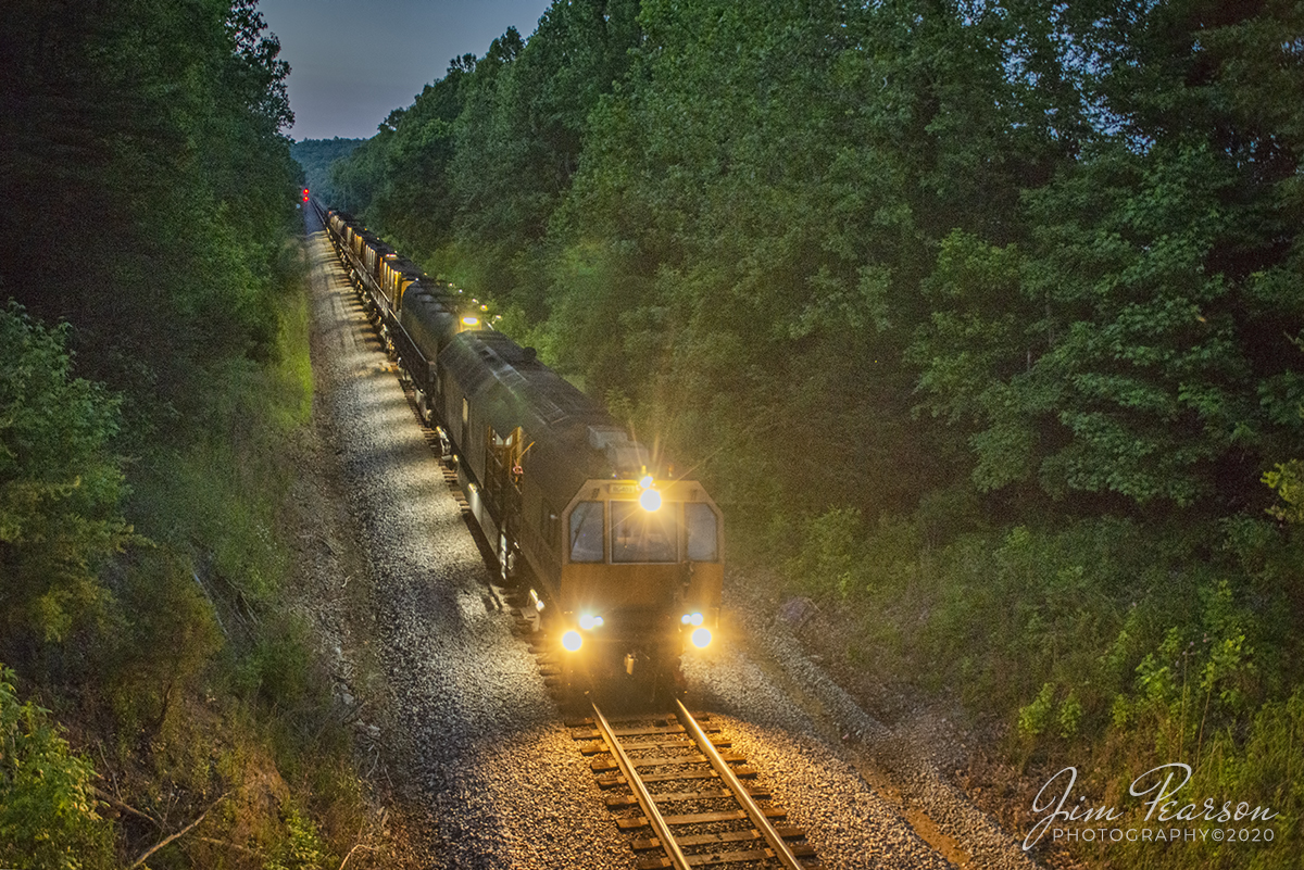 June 6, 2020 - LORAM Railgrinder 403 approaches the Davis Road overpass just south of Mannington, Kentucky, as it heads south to it's next grinding spot on the Henderson Subdivision, as it's lights illuminate the right-of-way in the fading daylight. 

According to Wikipedia: A rail grinder is a maintenance of way vehicle or train used to restore the profile and remove irregularities from worn tracks to extend its life and to improve the ride of trains using the track.

Tech Info: Full Frame Nikon D800, RAW, Sigma 24-70 @ 24mm, f/2.8. 1/160, ISO 3200.