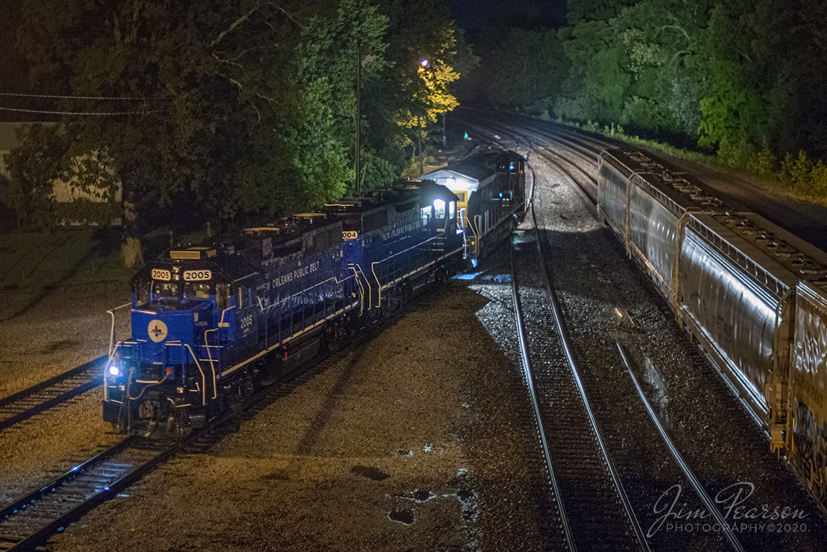 The conductor on CSX Q513 shines a light on the track ahead from the nose of New Orleans Public Belt Railroad (NOPD) 2005 as it and 2004 are backed into Howell Yard in Evansville, Indiana to perform a pickup before continuing its trip on south along the Henderson Subdivision on a wet and cool summer night.

According to a press release from  The New Orleans Public Belt Railroad (NOPB), it is in the process of upgrading its locomotive fleet with eight new locomotives to replace aging engines, improve efficiency, and lower overall emissions. Recognizable by their bright blue color, the new locomotives will provide reliable service and support the short-line railroads commitment to integrating more sustainable business and operational practices.

The new EPA-classified Tier One locomotives will allow NOPB to reduce its fleet size by 46 percent, from 15 locomotives to eight. Fuel consumption will be reduced by 25 percent, and emission reductions include a 40 percent reduction in nitrous oxide (NOx), which pollutes the ozone layer and creates smog, along with a 50 percent reduction in particulate emissions.

In addition to fuel and emissions savings, the new leasing structure allows NOPB to achieve significant operational and capital savings.

These are two of their new locomotives that are dead-in-tow on Q513 heading south to their new home.

According to Wikipedia: The New Orleans Public Belt Railroad (reporting mark NOPB) is a Class III railroad, and a subsidiary of the Port of New Orleans. It connects with six Class I railroads serving the city, and provides switching and haulage service. It is estimated that one-third of the United States' east-west rail freight crosses the Mississippi on the Huey P. Long Bridge segment of the railroad.

The impetus for the NOPB came at the start of the 20th century era when multiple railroads terminating locally created both congestion at the Port of New Orleans and safety problems on city streets. The railroad began operation in 1908 with the intention of giving the major railroads "uniform and impartial" access to the port.

Tech Info: Nikon D800, RAW, Nikkor 50mm, f/1.4, 1/30, ISO 3,600.