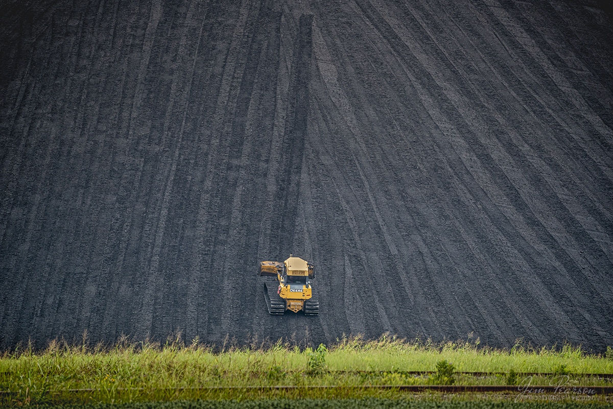 That's a lot of coal!!

A driver uses a John Deer Bulldozer to push and smooth coal up a very large pile at the Calvert City Terminal in Calvert City, Kentucky. In case you're wondering, it takes a lot of coal and coke trains to build a pile that high and they come from Paducah & Louisville Railway, BSNF, CSX, Union Pacific and occasionally Norfolk Southern to add to the piles at the terminal, where the coal and coke is blended and transloaded onto barges and trains for shipment where ever the customer is.

When you're out shooting pictures trackside, don't forget that not every shot needs to have the train! Look for the details and work surrounding the operation as there's always great pictures to be had!

Tech Info: Nikon D800, RAW, Sigma 150-600 @ 390mm, f/6.3, 1/800, ISO 900.