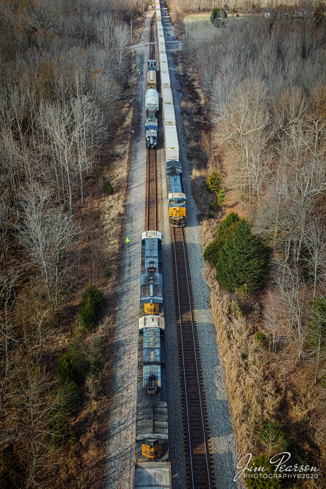 A three-way meet at the north end of Cedar Hill, Tennessee

Crews on CSX W991-29 and E305 do a roll-by inspection during a three way meet with hot intermodal Q029-07 at the north end of Cedar Hill, Tennessee as it heads south along the Henderson Subdivision, on December 5th, 2020.

W991-29 is carrying a GE high and wide load on GECX 021155 Heavy load, 16-axle, depressed center flat car, which is owned by General Electrical Gas Turbine division. The car is 147 feet 10 inches long and the load deck length is 38 feet according to what I find on the web. It Was built in May of 1995 and is used to transport heavy gas turbines built by General Electric. A Kasgro Rail Corporation (KRL) caboose 072 brings up the rear with a full crew. The caboose and engine crews kept a close eye on clearances as they made their way at 25mph! 

Tech Info: DJI Mavic Mini Drone, JPG, 4.5mm (24mm equivalent lens) f/2.8, 1/400, ISO 100.