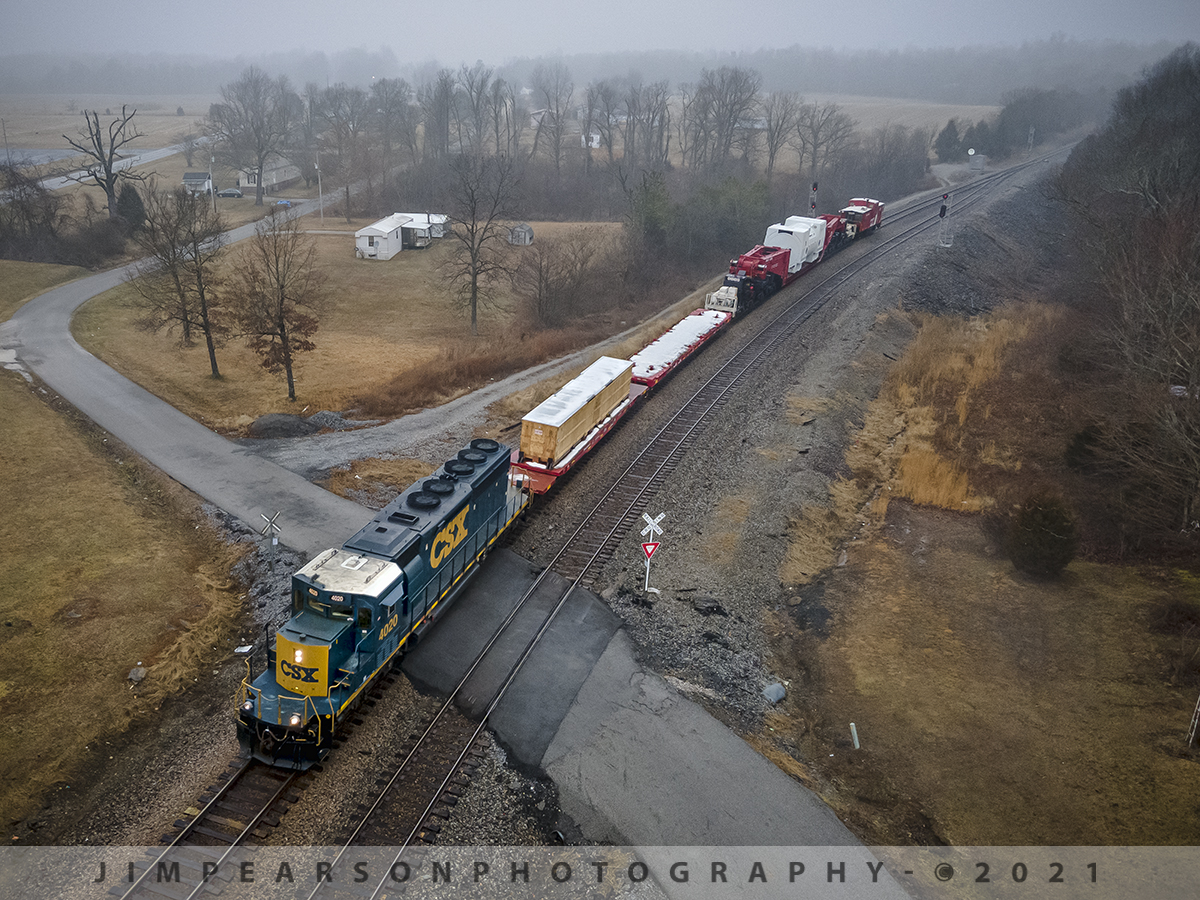 CSX W992-06 High and Wide Clear North Kelly

The rain stopped long enough on February 10th, 2021, where I could put up my Air 2 Drone twice for CSX high and wide train W992-06 as it headed south on the Henderson Subdivision. In this shot I caught it as it passed through the crossing at the north end of the siding at Kelly, Kentucky.

This was an Emmert International train move with CSXT SD40-3 #4020 as power and BBCX 1002 as the trailing manned caboose with what appeared to be a steam generator of some sort that was being hauled on their BBCX1000 Schnabel Railcar.

According to the Emmert International website: "Emmert Internationals BBCX1000 Schnabel Railcar is specifically designed to carry heavy (up to 1 million pounds) and oversized loads in such a way that the load itself makes up part of the car. The load is suspended between the two ends of the cars by lifting arms; the lifting arms are connected to a pivot above an assembly of pivots and frames that carry the weight of the load and the lifting arm.

For loads not designed to be part of the car Emmert Internationals BBCX1000 is equipped with a deck designed to carry the loads in standard configuration up to 836,000 pounds. Customized decks can be manufactured to increase the overall payload weight. 

Emmert Internationals BBCX1000 is equipped with hydraulic equipment that will either lift the load vertically or horizontally shift the load while in transit to clear obstructions along the cars route.
With 20 axles (ten for each half) containing four trucks connected by a complex system of span bolsters its tare (unloaded) weight without deck is 424,000 lbs. The BBCX1000s empty car length is 115 10 with a maximum length with the loading deck at 168 9. Maximum vertical load shifting ability is 14 and the maximum horizontal load shifting ability is 22. The heavy duty AAR railcar mechanical designation is LS."

Emmert Internationals BBCX1000 Schnabel Railcar is accompanied by the BBCX 1002 Caboose and BBCX1003 flat car that carries the deck when not in service. The BBCX1000 is pulled by special train service and requires 2 operators. When in transport not carrying loads the BBCX is limited to 40 mph. When loaded or empty with deck in place the BBCX1000 is limited to 25 mph."

The crews that control the BBCX 1000 railcar ride in the caboose.

Tech Info: DJI Mavic Air 2 Drone, RAW, 4.5mm (24mm equivalent lens) f/2.8, 1/200, ISO 200.