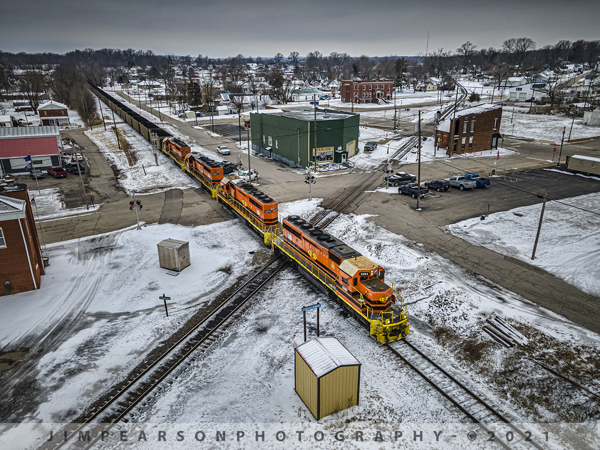 Indiana Southern IPL load northbound at Oakland City, IN

Another load of black coal crosses over the Norfolk Southern east-west line as Indiana Southern Railroad (ISRR) 3383, 3372, 3371 and 3386 lead their train north on their Petersburg Subdivision at Oakland City, Indiana on a very cold February 13th, 2021.

They will continue their move for another 20-30 miles or so through the freezing snow and ice to the Indiana Power and Light power plant at Petersburg, Indiana. As they repeat this run 3-6 times a week from Peabody's Wildboar Mine in Lynnville, IN.

According to Wikipedia: The Indiana Southern Railroad (reporting mark ISRR) is a short line or Class III railroad operating in the United States state of Indiana. It began operations in 1992 as a RailTex property, and was acquired by RailAmerica in 2000. RailAmerica was itself acquired by Genesee & Wyoming in December 2012.

Indiana Southern Railroad operates 186 miles of track from Indianapolis to Evansville. From Mars Hill (a neighborhood on the southwest side of Indianapolis) southwest through Martinsville and Spencer to Bee Hunter in Greene County, the ISRR runs on tracks that once made up the majority of the former Indianapolis & Vincennes Branch of the Pennsylvania Railroad. State Route 67 parallels the ISRR along much of this section. From Bee Hunter to Elnora the ISRR has trackage rights over the Indiana Rail Road. ISRR tracks resume from Elnora through Washington in Daviess County, Petersburg in Pike County, Oakland City in Gibson County, Elberfeld in Warrick County and Daylight in Vanderburgh County before terminating in Evansville along the former New York Central's Evansville & Indianapolis Branch.

Tech Info: DJI Mavic Air 2 Drone, RAW, 4.5mm (24mm equivalent lens) f/2.8, 1/500, ISO 100.