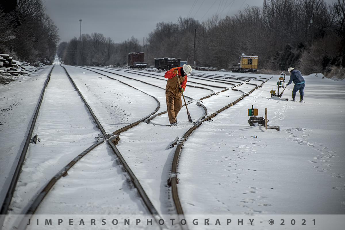 Broom work is never done after a good snow on the PAL!

It's February 16th, 2021 and a cool 10 degrees outside (even colder with the wind chill) as two Paducah and Louisville Railway employees work on clearing snow and ice from the switches at West Yard in Madisonville, Kentucky.

On shortline and regional railroads this scene is repeated a lot, even on many of the class ones, epically with the recent snow front that moved through much of south in areas that normally don't get snow! I'm told that CSX in the Nashville area had crews doing this same thing all around the city!

Remember, it's not always about the power on the railroad! It's folks behind the scenes like the maintainers, MOW folks, Dispatchers, ect. that make it all move!

Tech Info: Nikon D800, RAW, Nikon 70-300 @ 185mm f/5, 1/1250, ISO 100 -0.7 Exp. Comp.