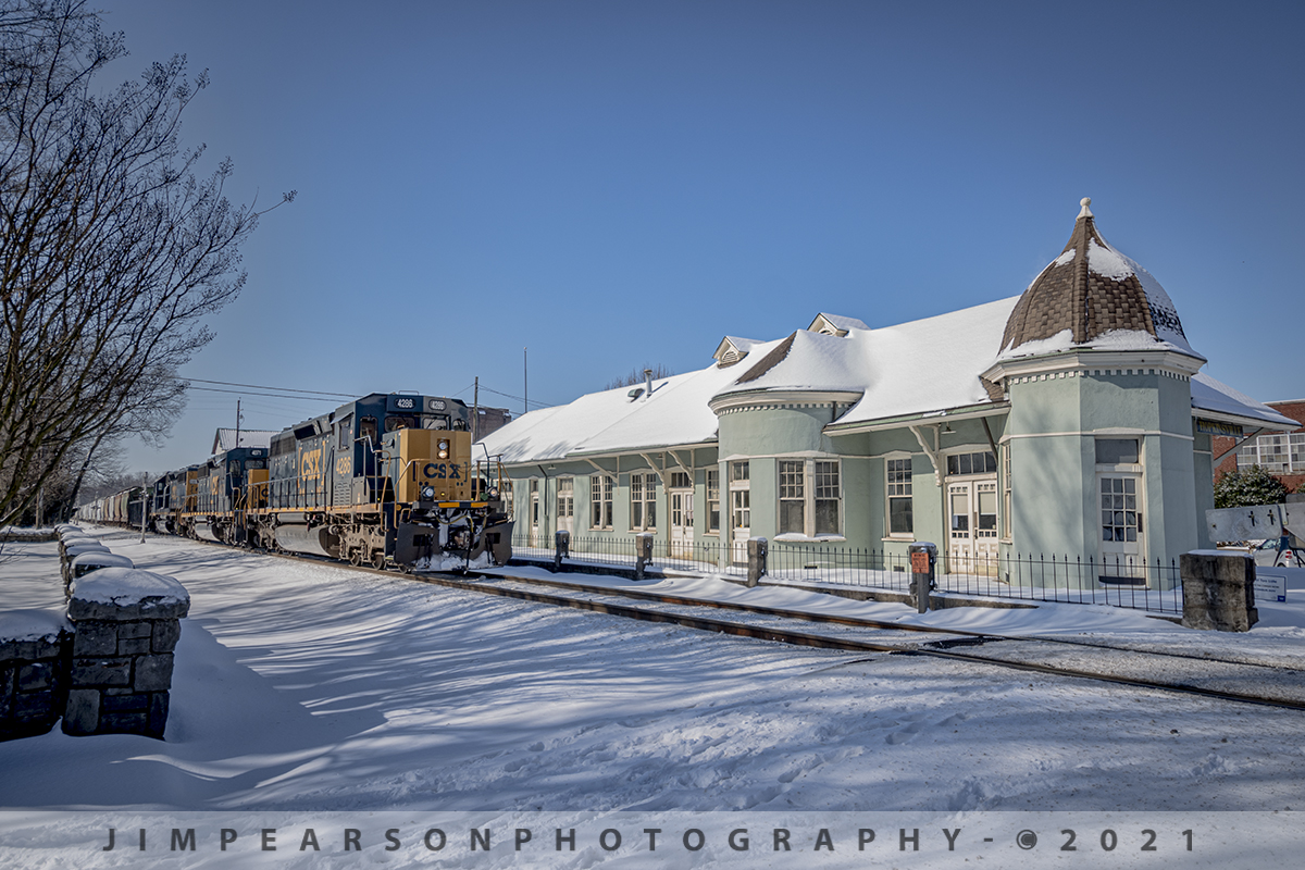 CSX Local J732 northbound passing the L&N Depot at Hopkinsville, Ky

This has been probably the best snow year we've had for a long time where in Western Kentucky, allowing for an abundance of favorite railroad snow scenes for me and this one taken on February 19th, 2021 is no exception!

CSX J732, the local between Casky Yard at Hopkinsville and Atkinson Yard in Madisonville, heads north past the old Louisville and Nashville Railway depot at Hopkinsville, Kentucky on the Henderson Subdivision, as a blanket of snow covers the ground and depot. Its running with a trio of SD 40's 4286 leading the way with a SD40-3.

According to Wikipedia: "The L &N Railroad Depot in the Hopkinsville Commercial Historic District of Hopkinsville, Kentucky is a historic railroad station on the National Register of Historic Places. It was built by the Louisville & Nashville Railroad in 1892. 

The year 1832 saw the first of many attempts to woo a railroad to Hopkinsville. This first attempt was to connect Hopkinsville to Eddyville, Kentucky. In 1868 Hopkinsville finally obtained a railroad station, operated by the Evansville, Henderson, & Nashville Railroad. The Louisville & Nashville Railroad acquired the railroad in 1879. 

The Hopkinsville depot is a single-story frame building with a slate roof. It has six rooms: A Ladies Waiting room (the room closest to the street), a General Waiting Room, a Colored Waiting Room, a baggage room (the furthest room from the street), a ticket office (the only room which connected to all three waiting rooms), and a ladies' restroom. Immediately outsides were warehouses for freight, usually tobacco. 

Its last long-distance (passenger) train was the Louisville and Nashville's Georgian, last operating in 1968. 

During its operating years, the Hopkinsville depot was a popular layover spot for those traveling by train. It was the only Louisville & Nashville station between Evansville, Indiana and Nashville, Tennessee where it was legal to drink alcohol. Hopkinsville got the nickname "Hop town" due to train passengers asking the conductors when they would arrive at Hopkinsville, so they could "hop off and get a drink".

The Hopkinsville L & N Railroad Depot was placed on the National Register of Historic Places on August 1, 1975. CSX, which bought out the Louisville & Nashville, still run trains on the tracks next to the depot, but do not stop."

Tech Info: Nikon D800, RAW, Nikon DX 10-20mm lens @24mm (crop lens) f/4.5, 1/800, ISO 100.