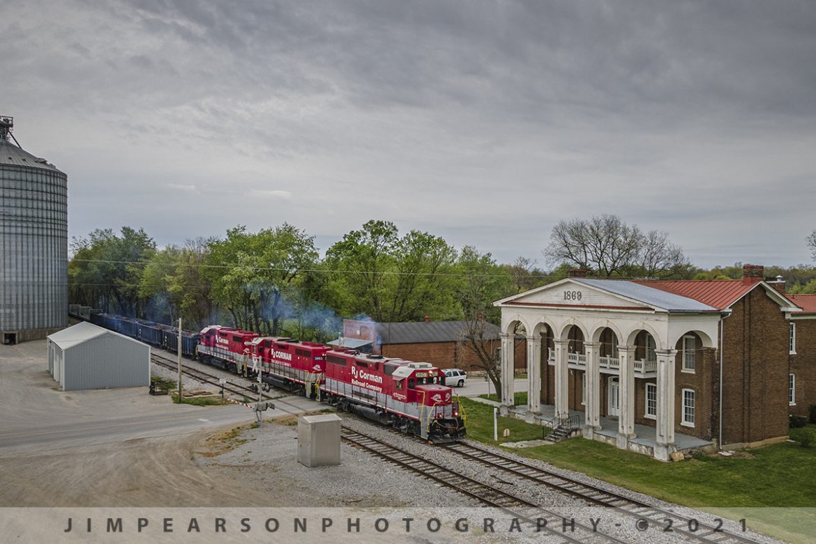 RJ Corman northbound at South Union, Kentucky on the Memphis Line

With the exhaust flowing behind the train, RJ Cormans 3803, 3863 and 3837 lead MR22 northbound on April 14th, 2021 as they pass the 1869 Shaker Tavern at South Union, Kentucky on an overcast spring day. Their next stop is the RJ Corman Railroad Distribution Center outside Russellville, Ky where they cut off this power and another train set combined its train with it and took the train on north on the Memphis Line.

According to Roadtrippers.com: The Shaker Tavern, built in 1869 as a business venture for the South Union Shakers, housed a hotel for the "people of the world." The Shakers leased the building to an outside interest for one hundred dollars a month, leaving its management to the "world." The Shaker Tavern maintained a thriving business for more than forty years, catering to the Victorian railroad travelers who stopped at South Union. The building's architectural features were clearly incorporated to attract the world's people, whose tastes differed dramatically from that of the Shakers. The stark simplicity of the buildings used by the Shakers contrasts greatly with the grand columned facade, intricate brickwork, and the ornate staircase of the Shaker Tavern.

Tech Info: DJI Mavic Air 2 Drone, RAW, 4.5mm (24mm equivalent lens) f/2.8, 1/400, ISO 100.