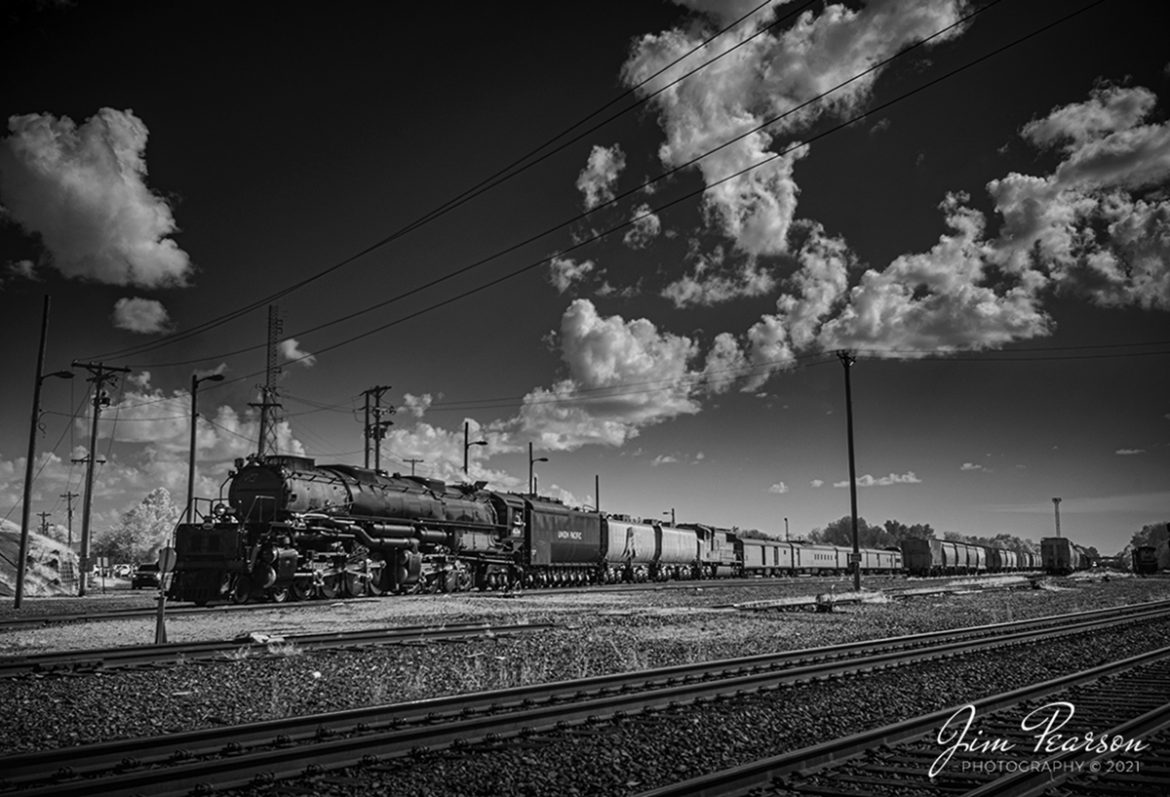An infrared photograph of Union Pacific's 4014, Big Boy as it backs into the static display area at Popular Bluff, Arkansas on UP's Hoxie Subdivision, on August 27th, 2021, during its overnight stop on their month-long tour around the United States.

The Big Boy is an articulated 4-8-8-4 steam locomotive which was manufactured by the American Locomotive Company (ALCO) of Schenectady, New York in 1941. There were a total 25 of these giants built and of the eight remaining locomotives this is the only operational one. 

According to Wikipedia: The locomotive operated in revenue service until 1959, when it was donated to the Railway and Locomotive Historical Society in late 1961 and thereafter displayed in Fairplex at the RailGiants Train Museum in Pomona, California. 

In 2013, UP re-acquired the locomotive and launched a restoration project at their Steam Shop in Cheyenne, Wyoming. In May 2019, No. 4014 was operated for the first time after sitting dormant for almost six decades. 

It ran its first excursion, double-headed with Union Pacific 844, three days later on May 4, 2019. Now part of the Union Pacific's heritage fleet, it now operates in excursion service, in addition to hauling revenue freight during ferry moves.

Tech Info: Fuji XT-1, RAW, Converted to 720nm B&W IR, Nikon 12-24 @24mm, f/4.5, 1/500, ISO 200.