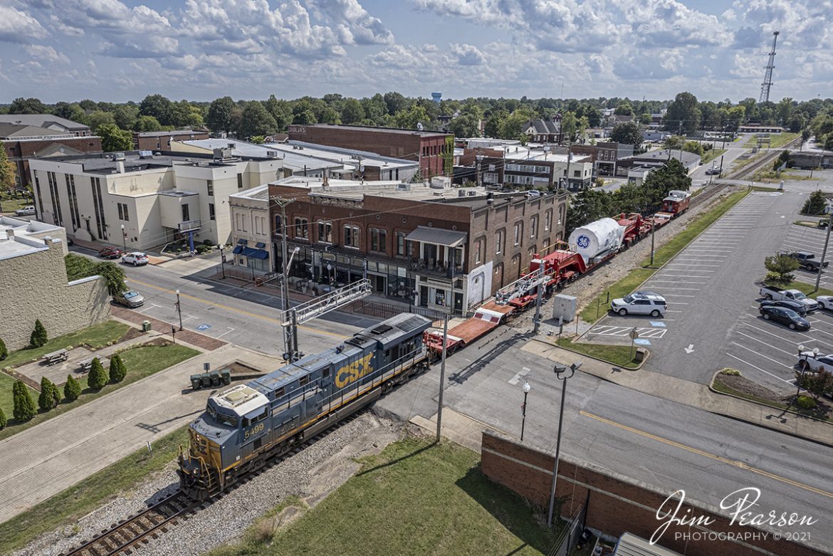 CSXT 5499 leads W995 through the crossing on West Center Street in downtown Madisonville, Kentucky as it heads north on the Henderson Subdivision with a General Electric high and wide load on September 13th, 2021.

These trains can take a long time to get from point A to Z as they are restricted normally to 25mph as their max speed when loaded and 5-10mph through turnouts. There is a GE crew on the caboose and their job is to watch and if needed shift the load to either side by a distance of 12 inches to allow clearance for passing trains or other obstacles.

Always an easy and interesting train to chase in my book! I had planned to chase it to Henderson, KY, but the crew ran out of their day and had to tie the train down at Hanson, but I still got a video and a couple of good shots between Nortonville and Hanson! It was a good day trackside!

Tech Info: DJI Mavic Air 2S Drone, RAW, 22mm, f/2.8, 1/2500, ISO 130.

#trainphotography #railroadphotography #trains #railways #dronephotography #jimpearsonphotography