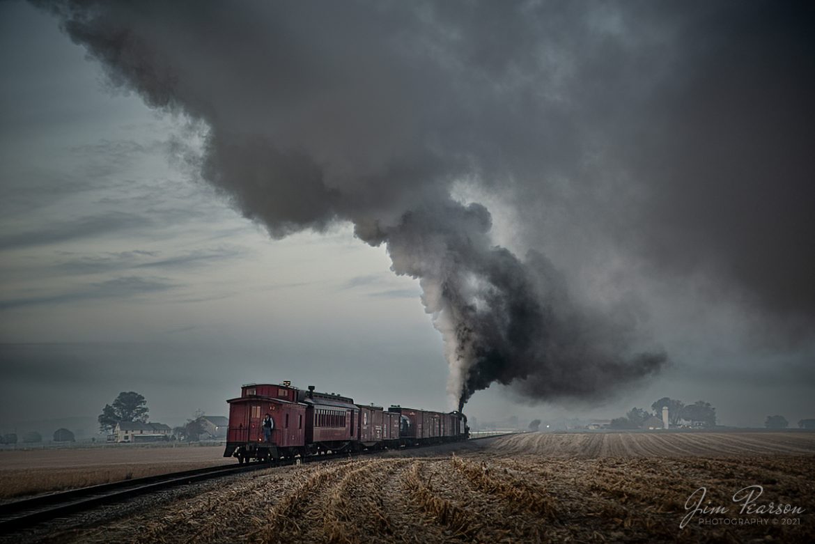 Conductor Gabriel Miranda stands on the back platform of caboose #12 as he talks to the crew on steam locomotive Norfolk & Western 475 during a reverse move just west of the Esbenshade Road Crossing, on the Strasburg Railroad at Strasburg, PA. They were conducting several photo run-bys prior to the sunrise during a Historic Transport Preservation, Inc, Steam Special from Strasburg on November 7th, 2021.

According to Wikipedia: Strasburg Railroad (Norfolk and Western) No. 475 is a 4-8-0 "Mastodon" type steam locomotive owned and operated by the Strasburg Railroad outside of Strasburg, Pennsylvania. Built by the Baldwin Locomotive Works in June 1906, it was part of the Norfolk and Western's first order of M class numbered 375-499. Today, No. 475 is the only operating 4-8-0 type in North America and the Strasburg Rail Road's oldest operating steam locomotive.

Tech Info: Nikon D800, RAW, Sigma 24-70 @ 52mm, f/2.8, 1/250, ISO 450.

#trainphotography #railroadphotography #trains #railways #jimpearsonphotography #trainphotographer #railroadphotographer