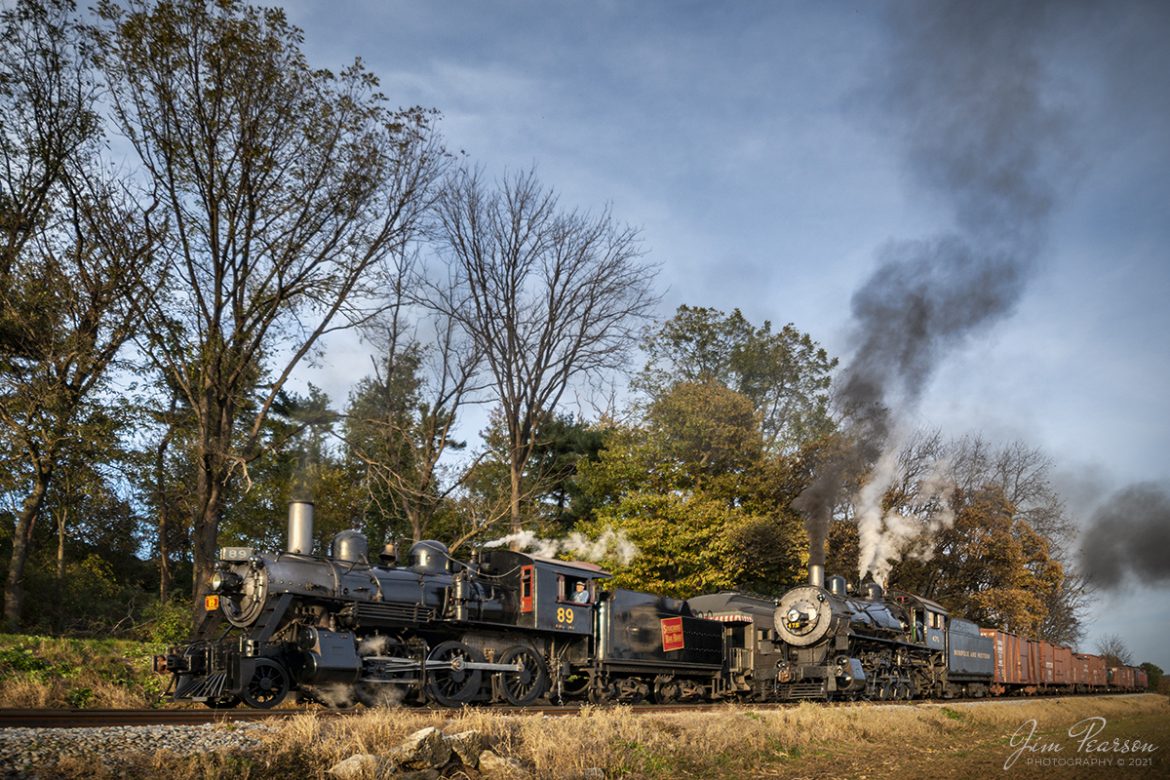 Norfolk and Western 475 waits in the siding at Groffs as Canadian National #89 passes on their way west on the Strasburg Railroad, with a loaded passenger train on November 7th, 2021, at Paradise Township, Pennsylvania.

According to Wikipedia: Strasburg Railroad (Norfolk and Western) No. 475 is a 4-8-0 "Mastodon" type steam locomotive owned and operated by the Strasburg Railroad outside of Strasburg, Pennsylvania. Built by the Baldwin Locomotive Works in June 1906, it was part of the Norfolk and Western's first order of M class numbered 375-499. Today, No. 475 is the only operating 4-8-0 type in North America and the Strasburg Rail Road's oldest operating steam locomotive.

Strasburg Railroad (Canadian National) No. 89 is a 2-6-0 "Mogul" type steam locomotive originally built by the Canadian Locomotive Company in February 1910 for the Canadian National Railway. It is now owned and operated by the Strasburg Railroad outside of Strasburg, Pennsylvania where it resides today for use on excursion trains.

Tech Info: Nikon D800, RAW, Nikon 10-20mm @ 14mm, f/4, 1/800, ISO 280.

#trainphotography #railroadphotography #trains #railways #jimpearsonphotography #trainphotographer #railroadphotographer