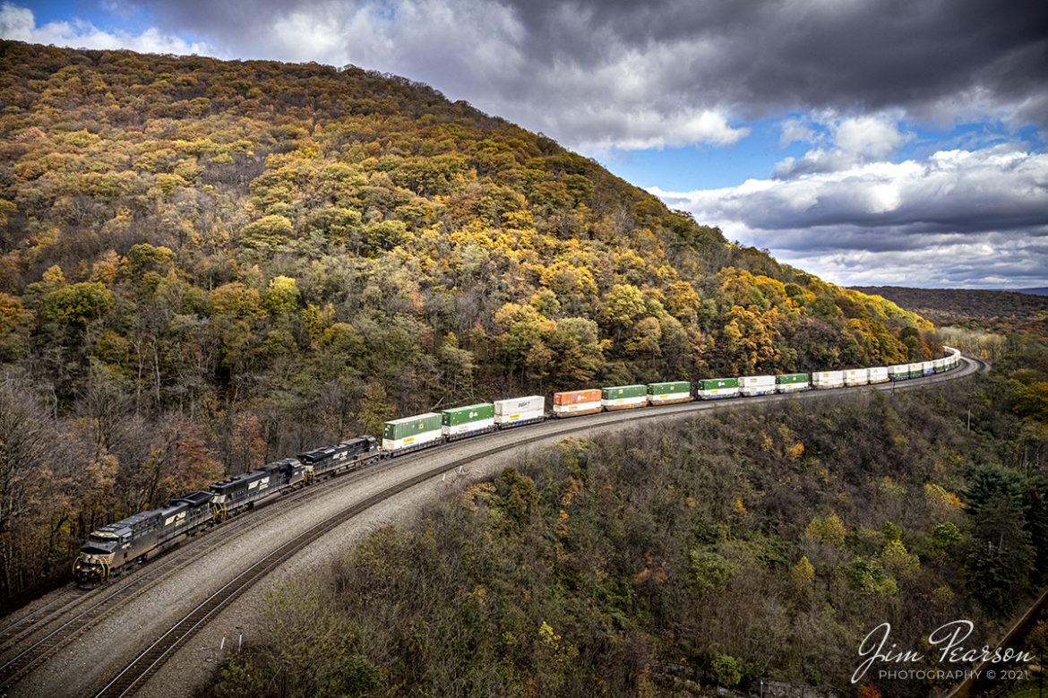 Norfolk Southern 4041, 1843, and 8016 lead an intermodal through Horseshoe Curve at Altoona, Pennsylvania as it heads west on the NS Pittsburgh Line on a beautiful fall afternoon, on September 3rd, 2021.

According to Wikipedia: Horseshoe Curve is a three-track (though originally four) railroad curve on Norfolk Southern Railway's Pittsburgh Line in Blair County, Pennsylvania. The curve itself is about 2,375 feet long and 1,300 feet in diameter; it was completed in 1854 by the Pennsylvania Railroad as a way to lessen the grade to the summit of the Allegheny Mountains. It eventually replaced the time-consuming Allegheny Portage Railroad, the only other route across the mountains for large vehicles. Because of the Allegheny Mountains geoform, in and around Altoona - and almost perfectly at "The Curve" - westbound traffic goes south and eastbound traffic goes north. So, in terms of final destination, the southern side of "The Curve" is where trains leave to go west, and vice versa.

The rail line has been important since its opening, and during World War II the Curve was targeted by Nazi Germany in 1942 as part of Operation Pastorius. The Curve was later owned and used by Pennsylvania Railroad successors Penn Central, Conrail, and Norfolk Southern. Horseshoe Curve was added to the National Register of Historic Places and designated a National Historic Landmark in 1966, and it became a National Historic Civil Engineering Landmark in 2004.

Horseshoe Curve has long been a tourist attraction; a trackside observation park was completed in 1879. The Park was renovated, and a visitor center built in the early 1990s. The Railroaders Memorial Museum in Altoona manages the center, which has exhibits pertaining to the curve.

Tech Info: DJI Mavic Air 2S Drone, RAW, 22mm, f/2.8, 1/725, ISO 100.

#trainphotography #railroadphotography #trains #railways #dronephotography #trainphotographer #railroadphotographer #jimpearsonphotography