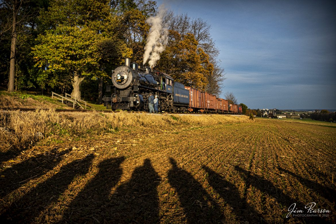 The waiting game! The long shadows from a group of railfans provide an interesting frame as they wait, along with the crew of Norfolk and Western 475, at Groffs Siding on the Strasburg Railroad, on November 7th, 2021, at Strasburg, Pennsylvania for a westbound passenger train to pass. 

According to Wikipedia: Strasburg Railroad (Norfolk and Western) No. 475 is a 4-8-0 "Mastodon" type steam locomotive owned and operated by the Strasburg Railroad outside of Strasburg, Pennsylvania. Built by the Baldwin Locomotive Works in June 1906, it was part of the Norfolk and Western's first order of M class numbered 375-499. Today, No. 475 is the only operating 4-8-0 type in North America and the Strasburg Rail Road's oldest operating steam locomotive.

Tech Info: Nikon D800, RAW, Nikon 10-24mm @ 17mm, f/4.2, 1/1600, ISO 500.

#trainphotography #railroadphotography #trains #railways #jimpearsonphotography #trainphotographer #railroadphotographer
