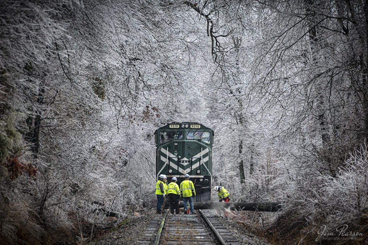 On a freezing cold afternoon CSX Z464, a Paducah and Louisville Railway, Louisville Gas and Electric coal train, waits on the PeeVee Spur as a CSX team works on clearing a downed tree in its path at Madisonville, Ky on February 3rd, 2022. 

After it was cut, the rest of the team man handled the cut piece off the track and the train continued its trip to Warrior Coal mine close to Nebo, Ky. The storm that moved across the country covered the trees with ice and this tree, along with many others throughout the path of the storm, fell due to the added weight of the ice. 

Tech Info: Nikon D800, RAW, Sigma 150-600 @ 420mm, f/8, 1/400, ISO 2000.

#trainphotography #railroadphotography #trains #railways #jimpearsonphotography #trainphotographer #railroadphotographer