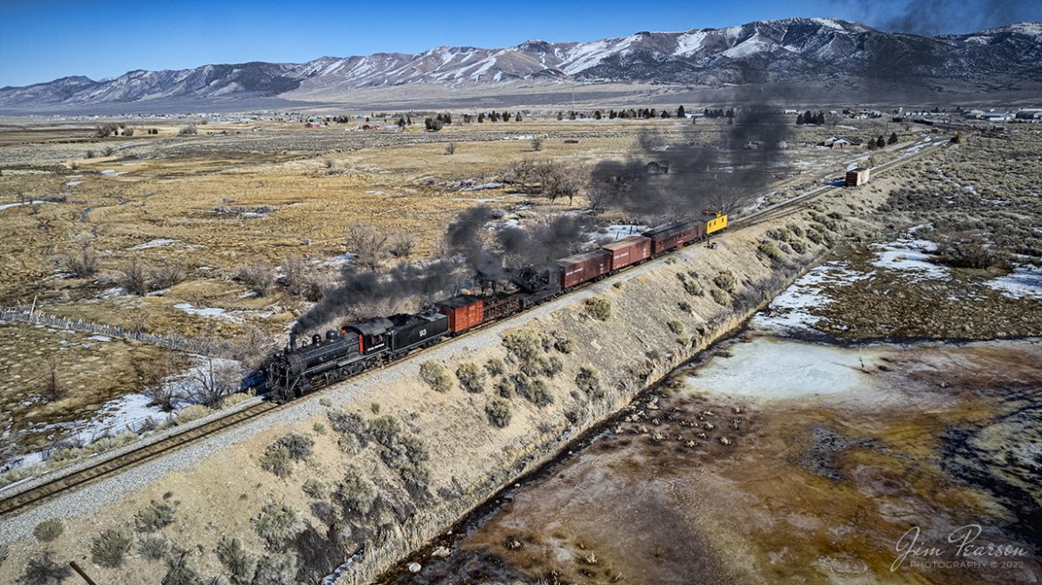 Nevada Northern Railway steam locomotive #93 pulls a wreck train southbound towards Robinson Canyon as it departs Ely, Nevada on the final day of their 3-day Winter Photography Charter on February 13th, 2022.

According to Wikipedia: The Nevada Northern Railway Museum is a railroad museum and heritage railroad located in Ely, Nevada and operated by a historic foundation dedicated to the preservation of the Nevada Northern Railway.

The museum is situated at the East Ely Yards, which are part of the Nevada Northern Railway. The site is listed on the United States National Register of Historic Places as the Nevada Northern Railway East Ely Yards and Shops and is also known as the "Nevada Northern Railway Complex". The rail yards were designated a National Historic Landmark District on September 27, 2006. The site was cited as one of the best-preserved early 20th-century railroad yards in the nation, and a key component in the growth of the region's copper mining industry. Developed in the first decade of the 20th century, it served passengers and freight until 1983, when the Kennecott Copper Company, its then-owner, donated the yard to a local non-profit for preservation. The property came complete with all the company records of the Nevada Northern from its inception.

Locomotive #93 is a 2-8-0 that was built by the American Locomotive Company in January of 1909 at a cost of $17,610. It was the last steam locomotive to retire from original revenue service on the Nevada Northern Railway in 1961 and was restored to service in 1993.

Tech Info: DJI Mavic Air 2 Drone, RAW, 4.5mm (24mm equivalent lens) f/2.8, 1/1600, ISO 100.

#trainphotography #railroadphotography #trains #railways #jimpearsonphotography #trainphotographer #railroadphotographer #nevadanorthernrailway #steamtrain