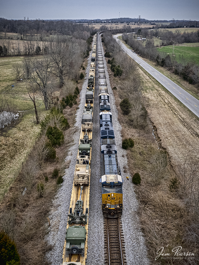 CSXT 3026 leads a combined 12,000 ft empty coal train E302 as it passes loaded military train S864 sitting in the siding at Kelly, Kentucky on the Henderson Subdivision on March 8th, 2022. 

CSX S864 is a Rose Lake, IL - Hopkinsville, Ky train and was returning the military equipment to Ft. Campbell, Ky from training exercises in the west, where Ft. Campbell Rail picked the train up off the Ft. Campbell Wye connection and took it onto the post.

Tech Info: DJI Mavic Air 2S Drone, RAW, 22mm, f/2.8, 1/1250, ISO 120.

#trainphotography #railroadphotography #trains #railways #dronephotography #trainphotographer #railroadphotographer #jimpearsonphotography