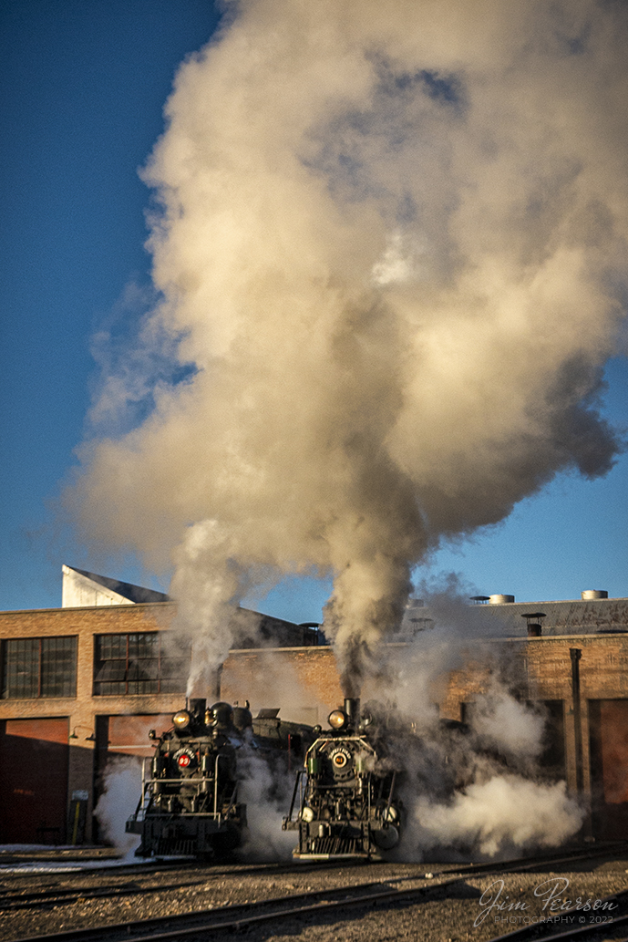 Early morning golden light rakes across the engine house as Nevada Northern Railway steam locomotives 93 and 81 pull out into the frigid air at Ely, Nevada, during the museums 2022 Winter Photo Charter event on February 12th, 2022.

According to Wikipedia: The Nevada Northern Railway Museum is a railroad museum and heritage railroad located in Ely, Nevada and operated by a historic foundation dedicated to the preservation of the Nevada Northern Railway.

The museum is situated at the East Ely Yards, which are part of the Nevada Northern Railway. The site is listed on the United States National Register of Historic Places as the Nevada Northern Railway East Ely Yards and Shops and is also known as the "Nevada Northern Railway Complex". The rail yards were designated a National Historic Landmark District on September 27, 2006. The site was cited as one of the best-preserved early 20th-century railroad yards in the nation, and a key component in the growth of the region's copper mining industry. Developed in the first decade of the 20th century, it served passengers and freight until 1983, when the Kennecott Copper Company, its then-owner, donated the yard to a local non-profit for preservation. The property came complete with all the company records of the Nevada Northern from its inception.

According to the NNRY website, #93 is a 2-8-0 that was built by the American Locomotive Company in January of 1909 at a cost of $17,610. It was the last steam locomotive to retire from original revenue service on the Nevada Northern Railway in 1961 and was restored back into service in 1993. 

Locomotive #81 is a "Consolidation" type (2-8-0) steam locomotive that was built for the Nevada Northern in 1917 by the Baldwin Locomotive Works in Philadelphia, PA, at a cost of $23,700. It was built for Mixed service to haul both freight and passenger trains on the Nevada Northern railway.

Tech Info: Nikon D800, RAW, Sigma 24-70 @ 24mm, f/7.1, 1/800, ISO 280.

#trainphotography #railroadphotography #trains #railways #jimpearsonphotography #trainphotographer #railroadphotographer #steamtrains #nevadanorthernrailway#trainphotography #railroadphotography #trains #railways #jimpearsonphotography #trainphotographer #railroadphotographer #jimpearsonphotography