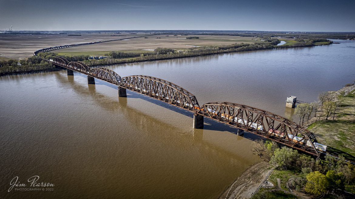 In this going away shot we see the full 8,256 feet of CSX I028 as it heads north across the Ohio River Bridge and viaduct on the CSX Henderson Subdivision from Henderson, Kentucky on April 19th, 2022. Between the viaduct and the bridge the total span above ground is just at 4.5 miles long.


The current viaduct and bridge were built by the L&N railroad and were dedicated on the last day of 1932 at a cost about $4 million. It replaced one erected in 1885, also built by the L&N, which at that time was the longest channel span of that type in the world at 2.3 miles long.


Tech Info: DJI Mavic Air 2S Drone, RAW, 22mm, f/2.8, 1/2000, ISO 160


#trainphotography #railroadphotography #trains #railways #dronephotography #trainphotographer #railroadphotographer #jimpearsonphotography