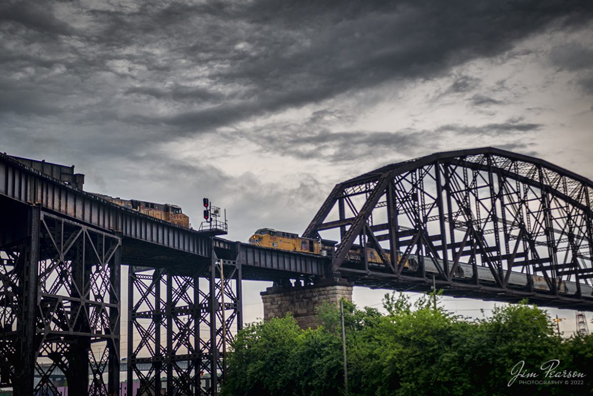 Two Union Pacific Railroad freights meet on the MacArthur Bridge on the TRRA MacArthur Subdivision in downtown St. Louis, Missouri on May 21st, 2022, under stormy skies. I really wanted to fly my drone for this shot, but unfortunately this area was a FAA no fly zone for drones.

According to Wikipedia: The MacArthur Bridge is a truss bridge that connects St. Louis, Missouri and East St. Louis, Illinois over the Mississippi River. The bridge was initially called the "St. Louis Municipal Bridge" and known popularly as the "Free Bridge" due to the original lack of tolls. Tolls were added for auto traffic beginning in 1932. In 1942, the bridge was renamed for Douglas MacArthur. 

Upon completion, the structure was the largest double-deck steel bridge in the world.

Tech Info: Nikon D800, RAW, Sigma 24-70 @ 40mm, f/3.5, 1/640, ISO 125.

#trainphotography #railroadphotography #trains #railways #jimpearsonphotography #trainphotographer #railroadphotographer