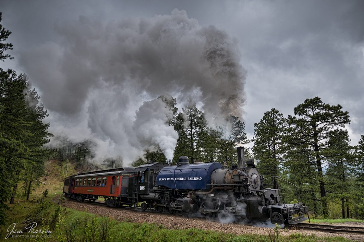 The Black Hills Central Railway locomotive 108 heads through the countryside as it makes its first trip of the day in stormy, wet weather of the forest to Keystone, South Dakota on my birthday, May 30th, 2022! I for one can't recall a better way to spend the day then chasing a steam locomotive and they later in the day riding it with family! Despite the wet and rainy weather, it was a great day, and I even got the drone up a few times! A big shout out to Cory Jakeway for all the help on finding my way around on the railroad and railfanning with me! 

According to their website: Locomotive #108 joined its nearly identical twin, #110, at the beginning of the 2020 season following a four-year restoration. It is a 2-6-6-2T articulated tank engine that was built by the Baldwin Locomotives Works in 1926 for the Potlatch Lumber Company. It later made its way to Weyerhaeuser Timber Company and eventually to the Northwest Railway Museum in Snoqualmie, Washington.

The acquisition and subsequent restoration of locomotive #108 completed a more than 20-year goal of increasing passenger capacity which began with the restoration of #110 and the restoration of multiple passenger cars. Both large Mallet locomotives (pronounced Malley) can pull a full train of seven authentically restored passenger cars, up from the four cars utilized prior to their addition to the roster.

Keep an eye out over the next few weeks for images from this 3,600-mile trip!

Tech Info: Nikon D800, RAW, Nikon 10-24mm @ 13mm, f/3.8, 1/400, ISO 250.

#trainphotography #railroadphotography #trains #railways #jimpearsonphotography #trainphotographer #railroadphotographer