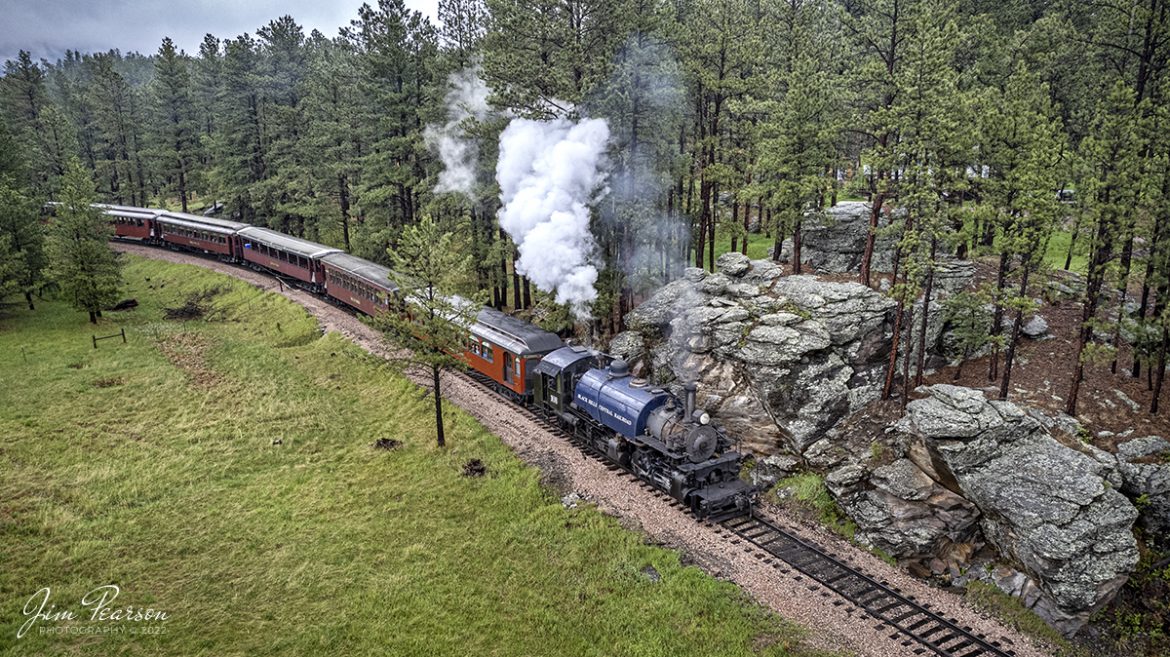 The Black Hills Central Railway locomotive 108 heads through the countryside as it makes its first trip of the day in stormy, wet weather through the Black Hills on its way to Keystone, South Dakota on my birthday, May 30th, 2022! 

According to their website: Locomotive #108 joined its nearly identical twin, #110, at the beginning of the 2020 season following a four-year restoration. It is a 2-6-6-2T articulated tank engine that was built by the Baldwin Locomotives Works in 1926 for the Potlatch Lumber Company. It later made its way to Weyerhaeuser Timber Company and eventually to the Northwest Railway Museum in Snoqualmie, Washington.

The acquisition and subsequent restoration of locomotive #108 completed a more than 20-year goal of increasing passenger capacity which began with the restoration of #110 and the restoration of multiple passenger cars. Both large Mallet locomotives (pronounced Malley) can pull a full train of seven authentically restored passenger cars, up from the four cars utilized prior to their addition to the roster.

Tech Info: DJI Mavic Air 2S Drone, RAW, 22mm, f/2.8, 1/320, ISO 200.

#trainphotography #railroadphotography #trains #railways #dronephotography #trainphotographer #railroadphotographer #jimpearsonphotography