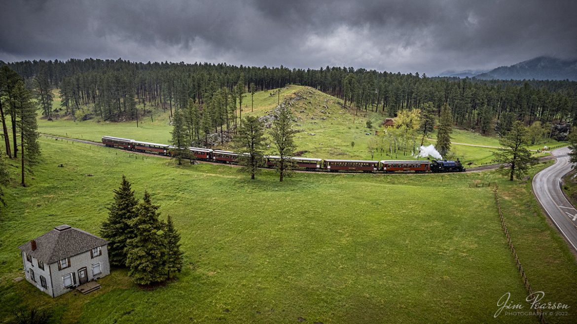 The 1880 Train, Black Hills Central Railroad locomotive crew on 108 blows for a crossing as the head through the Black Hills on the way to Keystone, SD on May 30th, 2022, under stormy skies. 

According to their website: Locomotive #108 joined its nearly identical twin, #110, at the beginning of the 2020 season following a four-year restoration. It is a 2-6-6-2T articulated tank engine that was built by the Baldwin Locomotives Works in 1926 for the Potlatch Lumber Company. It later made its way to Weyerhaeuser Timber Company and eventually to the Northwest Railway Museum in Snoqualmie, Washington.

The acquisition and subsequent restoration of locomotive #108 completed a more than 20-year goal of increasing passenger capacity which began with the restoration of #110 and the restoration of multiple passenger cars. Both large Mallet locomotives (pronounced Malley) can pull a full train of seven authentically restored passenger cars, up from the four cars utilized prior to their addition to the roster.

Tech Info: DJI Mavic Air 2S Drone, RAW, 22mm, f/2.8, 1/500, ISO 110.

#trainphotography #railroadphotography #trains #railways #dronephotography #trainphotographer #railroadphotographer #jimpearsonphotography