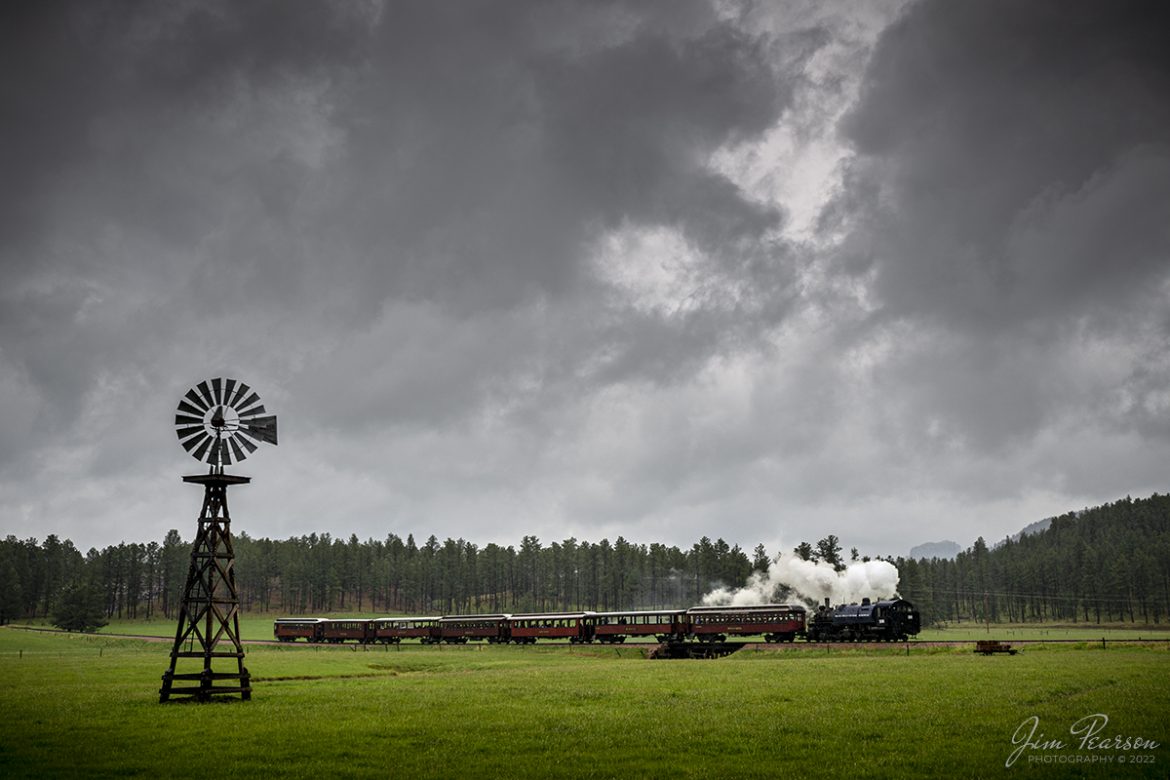 The 1880 Train, Black Hills Central Railroad locomotive 108 passes an old windmill in a flat section of the Black Hills as it pulls its train from Keystone to Hill City, SD on May 30th, 2022 under stormy skies.

According to their website: Locomotive #108 joined its nearly identical twin, #110, at the beginning of the 2020 season following a four-year restoration. It is a 2-6-6-2T articulated tank engine that was built by the Baldwin Locomotives Works in 1926 for the Potlatch Lumber Company. It later made its way to Weyerhaeuser Timber Company and eventually to the Northwest Railway Museum in Snoqualmie, Washington.

The acquisition and subsequent restoration of locomotive #108 completed a more than 20-year goal of increasing passenger capacity which began with the restoration of #110 and the restoration of multiple passenger cars. Both large Mallet locomotives (pronounced Malley) can pull a full train of seven authentically restored passenger cars, up from the four cars utilized prior to their addition to the roster.

Tech Info: Nikon D800, RAW, Sigma 24-70mm @ 24mm, f/4.5, 1/400, ISO 100.

#trainphotography #railroadphotography #trains #railways #jimpearsonphotography #trainphotographer #railroadphotographer #blackhillscentralrailroad #STEAM #steamtrains