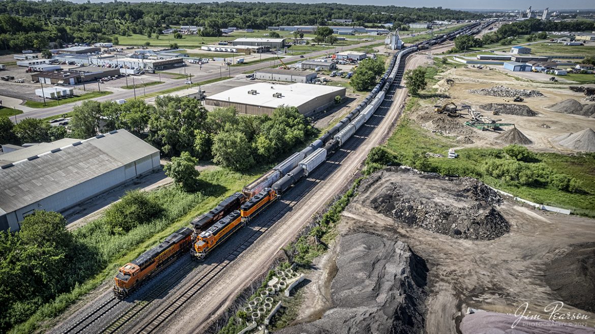 BNSF 2557 and 2604 work the BNSF yard on the BNSF Marshall Subdivision at Sioux City, Iowa on the morning of June 3rd, 2022, a line of shadows leads back to the city in the distance.

According to the Sioux City History Website: When Sioux City first began to grow, most people arrived by either steamboat or stagecoach. In the eastern United States, railroads were being built to connect all major cities. The first railroad to develop in Iowa was in 1865, along the Mississippi. However, plans were soon developed to expand the system to all major Iowa cities.

Sioux City developers knew that if the town wanted to become a major city, it would need to be one of the first to have railroad access. Not only did railroads move people, but they also moved materials and manufactured goods.

In the fall of 1866, a large crowd of local businessmen, bankers, and speculators met with a gentleman named W.W. Walker. He was a representative of John Blair, a wealthy eastern railroad developer. Mr. Blair was planning on building the Sioux City and Pacific Railroad. This railroad would connect the city with the main line which ran through Missouri Valley. This would give the city connections all the way to Chicago and back east. All the city and county had to do was provide free land for the tracks and for the depot. The county agreed to donate the land in February of 1867. The deal was struck.

Tech Info: DJI Mavic Air 2S Drone, RAW, 22mm, f/2.8, 1/1500, ISO 120.

#trainphotography #railroadphotography #trains #railways #dronephotography #trainphotographer #railroadphotographer #jimpearsonphotography