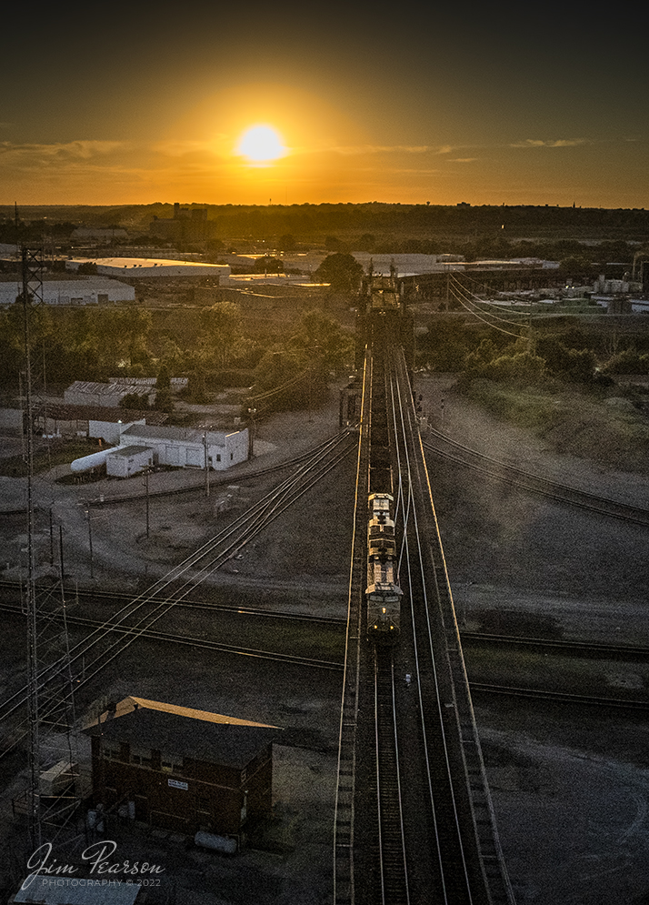 A Union Pacific loaded coal train heads across Santa Fe Junction on the Kansas City Terminal Railroad (KCT) High Line at sunset as it approaches Tower #3, on June 29th, 2022.

Santa Fe Junction sees on average over 100 trains a day and it hosts the double decked railroad (ATSF Double Deck Railroad) bridge that crosses the Kansas River into Missouri, a triple crossing in addition to Tower 3, which is used by maintenance of way these days. The junction is partly in Missouri and Kansas and sees BNSF, UP, KCT, Amtrak, KCS, NS and CP traffic.

The Kansas City Terminal Railway Company (KCT) is a Class III railroad located in Kansas City, Missouri and Kansas City, Kansas. KCT serves as a terminal railroad for its five Class I railroad owners (Union Pacific, BNSF, Kansas City Southern, Norfolk Southern and Canadian Pacific).  Amtrak also operates over the KCT providing passenger service to and from Union Station. Currently the second largest rail hub in the United States, KCT owns and dispatches 95 miles of track spanning Missouri and Kansas.

Tech Info: DJI Mavic Air 2S Drone, RAW, 22mm, f/2.8, 1/8000, ISO 110 underexposed by 3 stops for the sun.

#trainphotography #railroadphotography #trains #railways #dronephotography #trainphotographer #railroadphotographer #jimpearsonphotography
